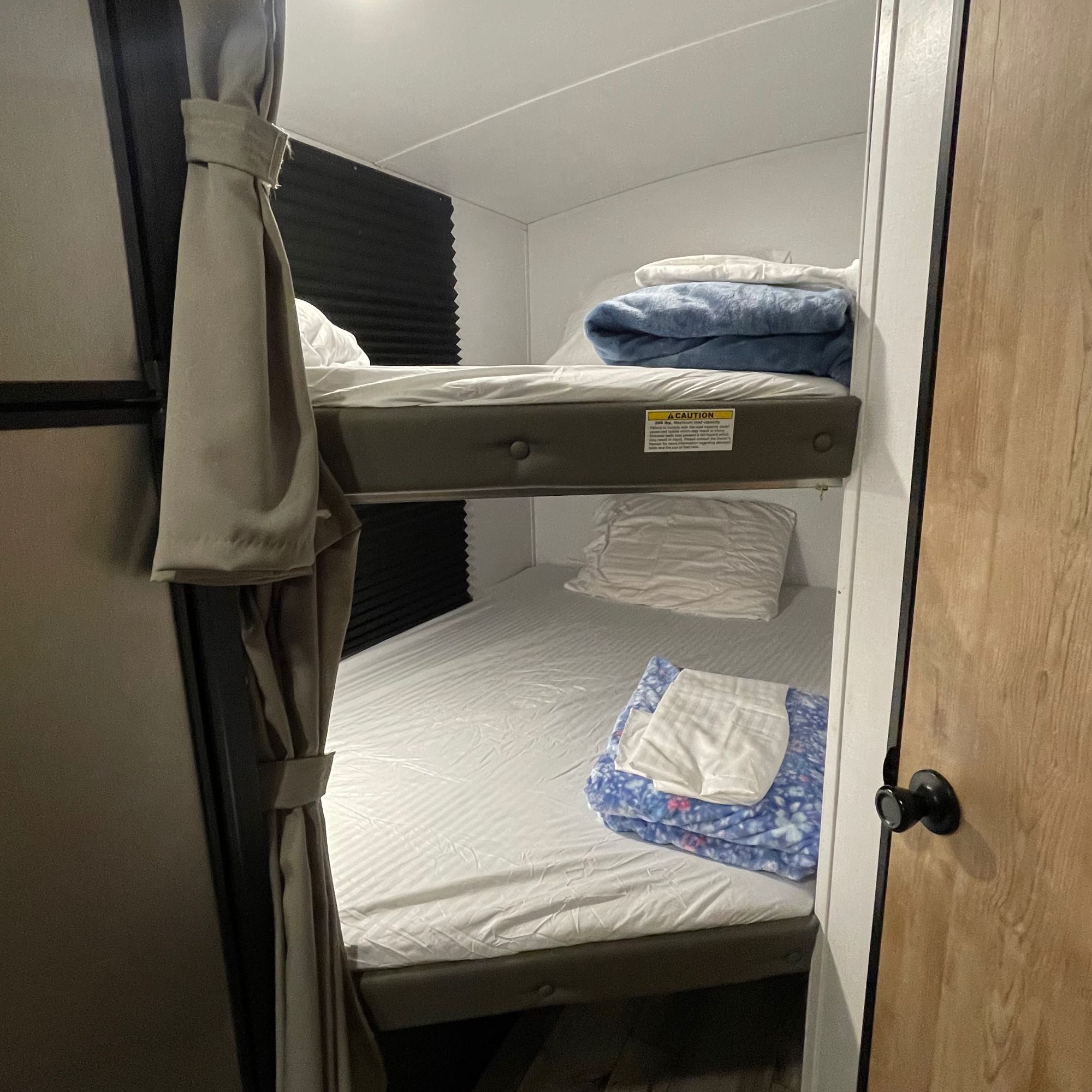 Cozy stacked bunk beds with fresh bedding are ready for guests inside this RV rental.. Keystone RV Springdale 2022