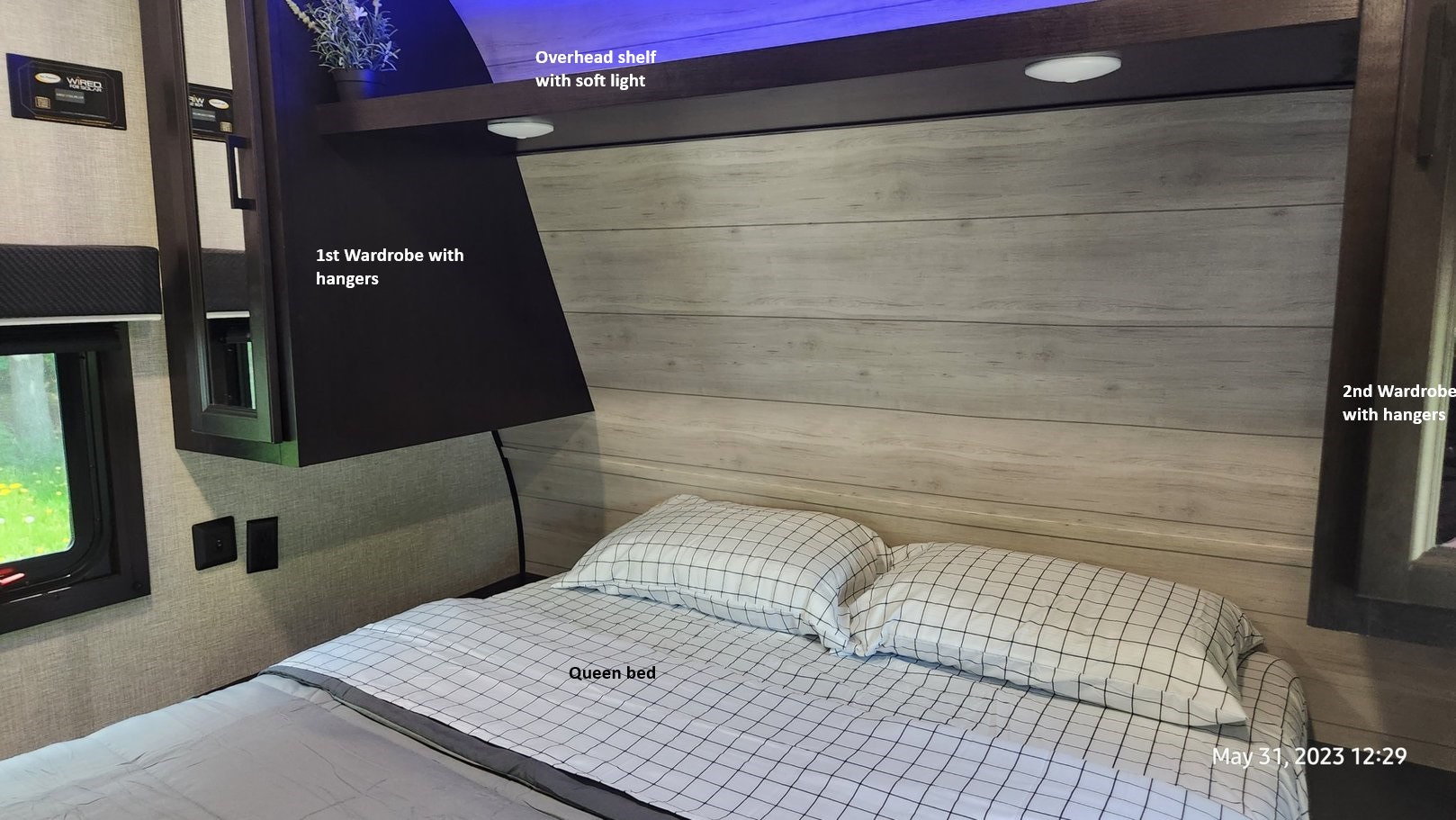 Inside an RV rental bedroom featuring a queen bed, overhead shelf with soft light, and two convenient wardrobes.. Jayco Jay Flight SLX 2023