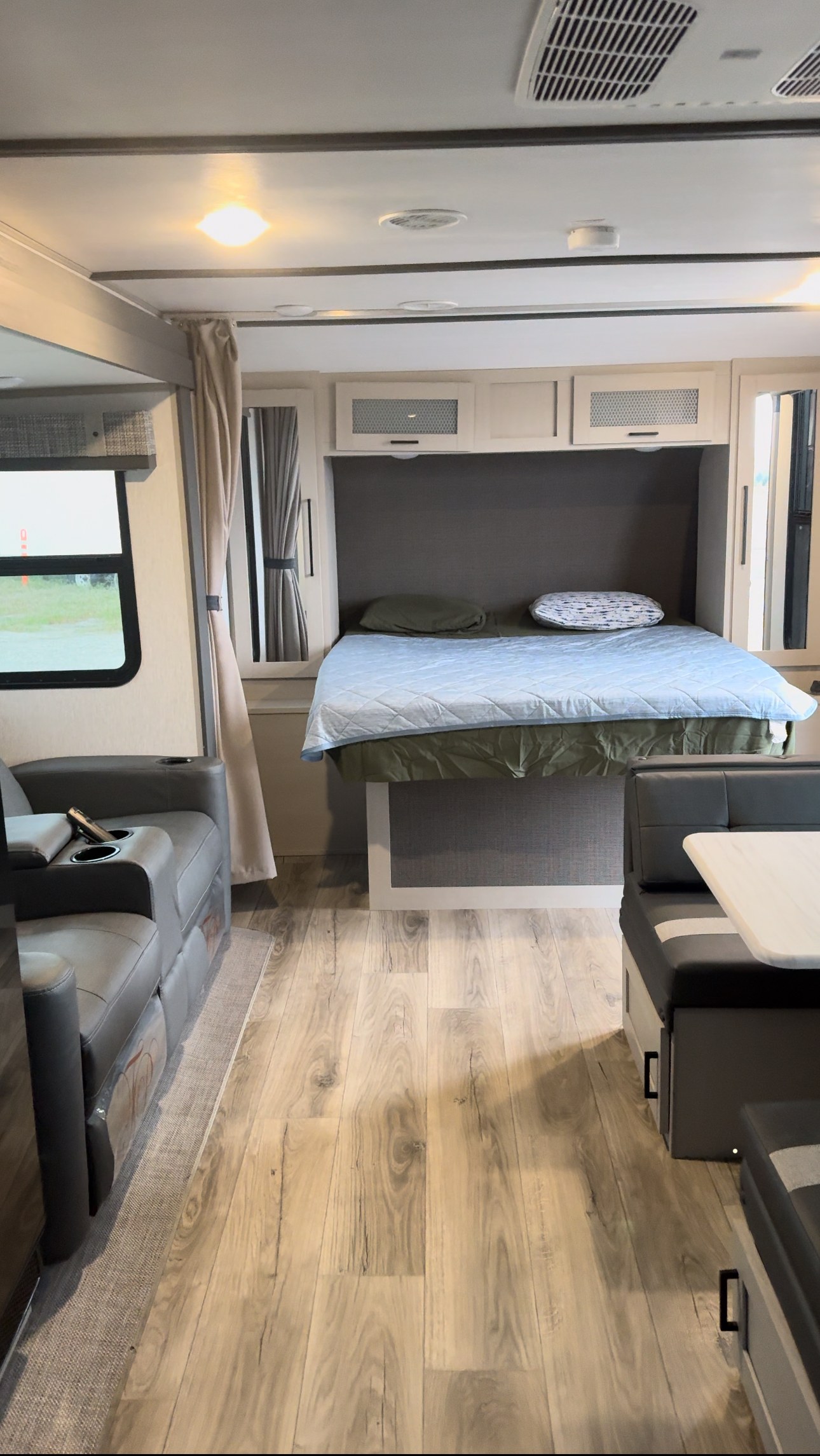 Modern RV rental interior with a comfortable bed, sofa, and dining booth. Clean design, perfect for travel.. Forest River Salem Hemisphere HL 2023