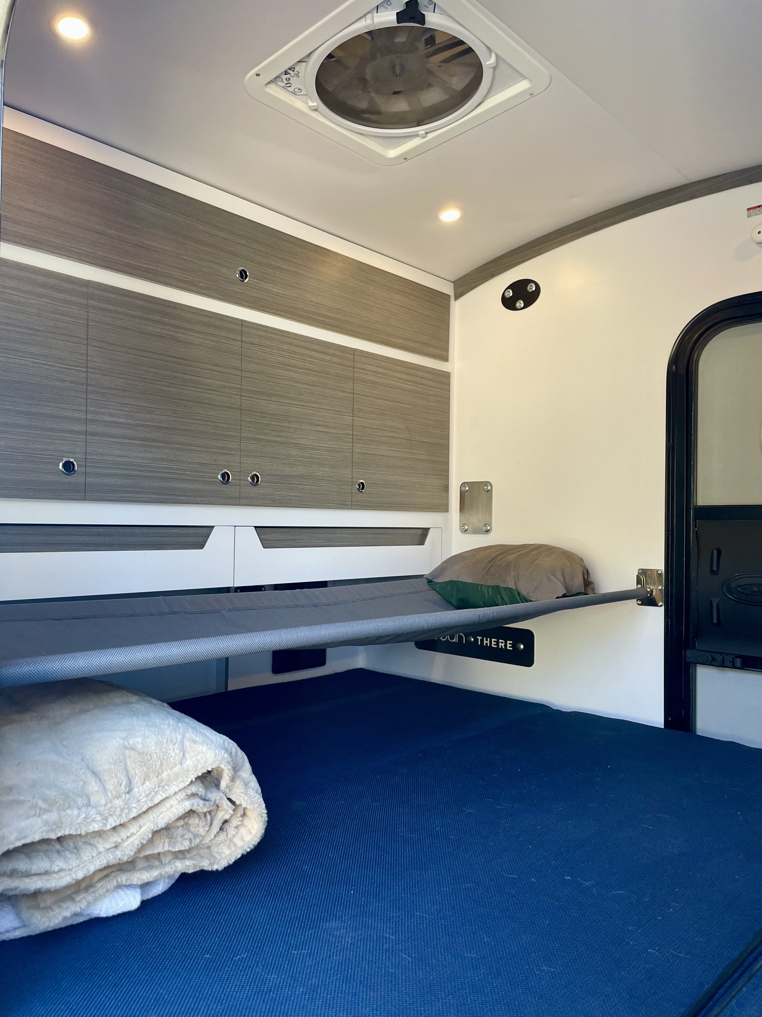 RV rental interior featuring bunk beds, storage cabinets, and a lower bed, ideal for compact adventure travel.. Bean Trailer Bean Trailer Trailer 2020