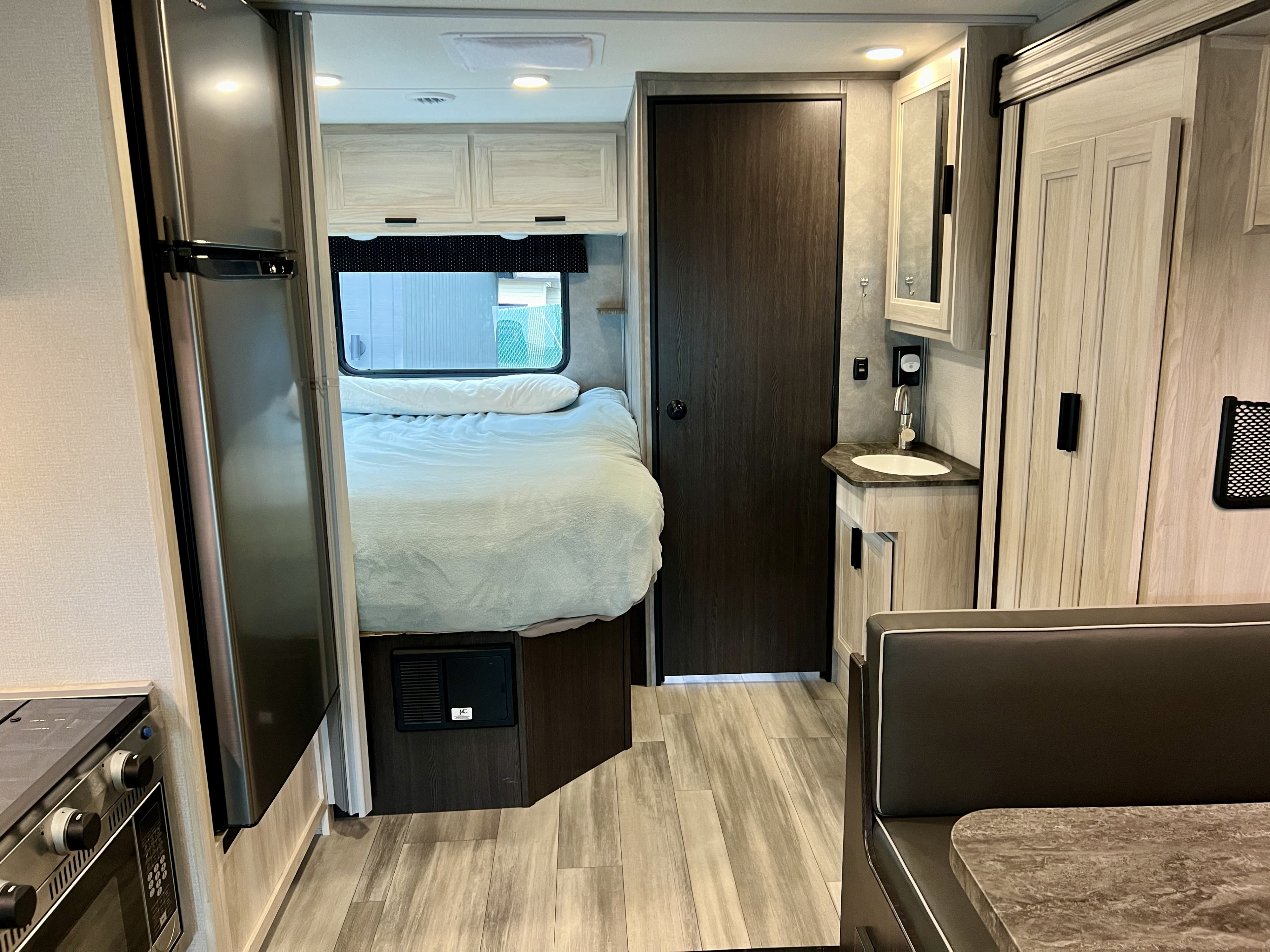 Clean rv rental interior shows a bed, kitchen, bath vanity, and dinette. Ideal camper layout for comfortable trips.. Forester LE 2023