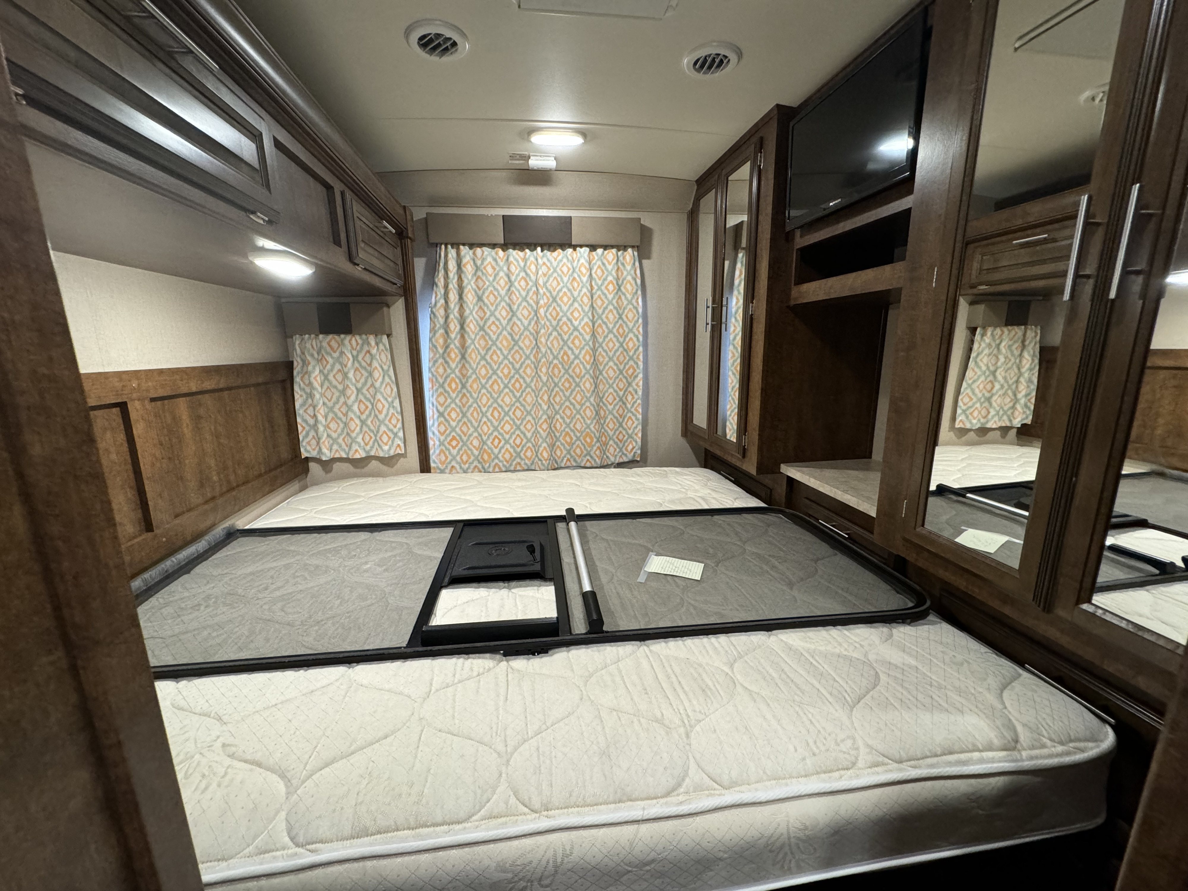 RV rental bedroom: a comfy mattress, raised bed base, overhead cabinets, TV, and mirrored closet. Ready for your trip!. Forest River FR3 2016