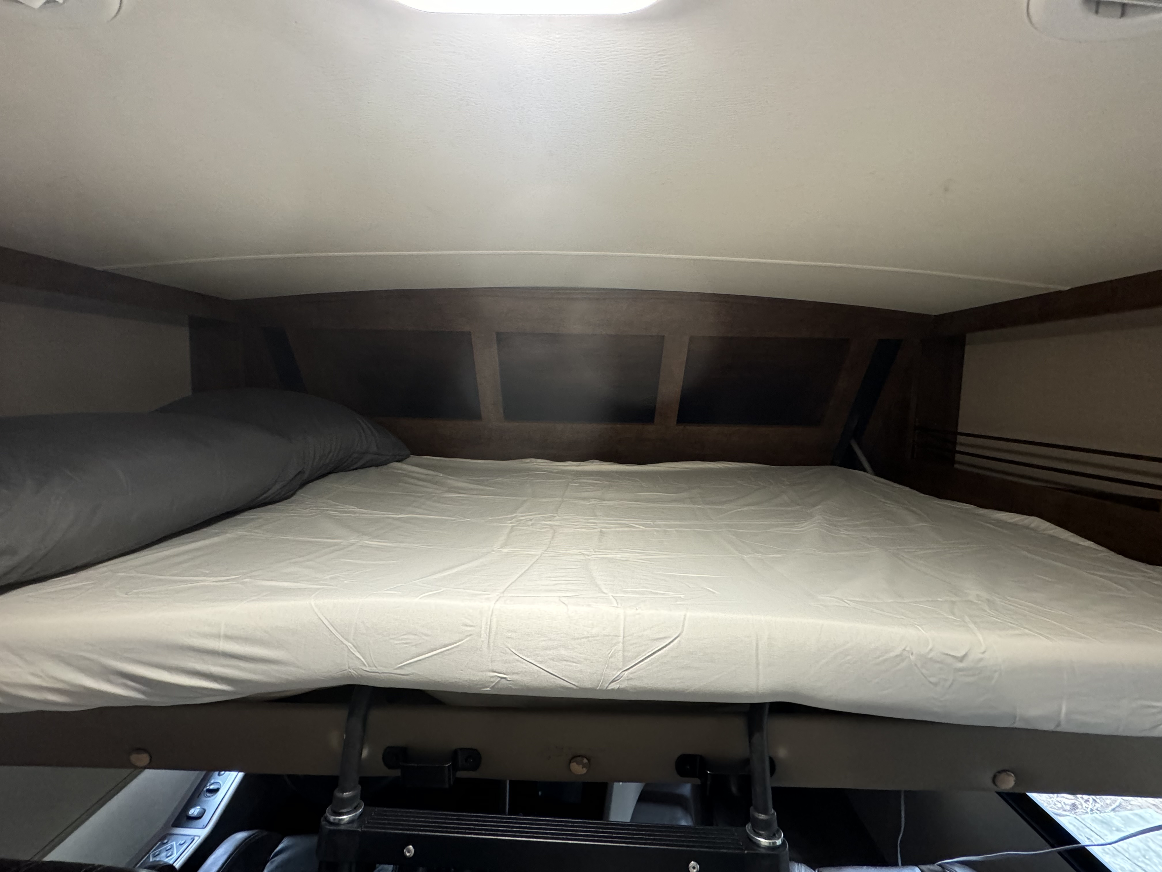 RV rental: View of a cozy, neatly made cab-over bunk bed with a gray pillow and light sheets.. Forest River FR3 2016
