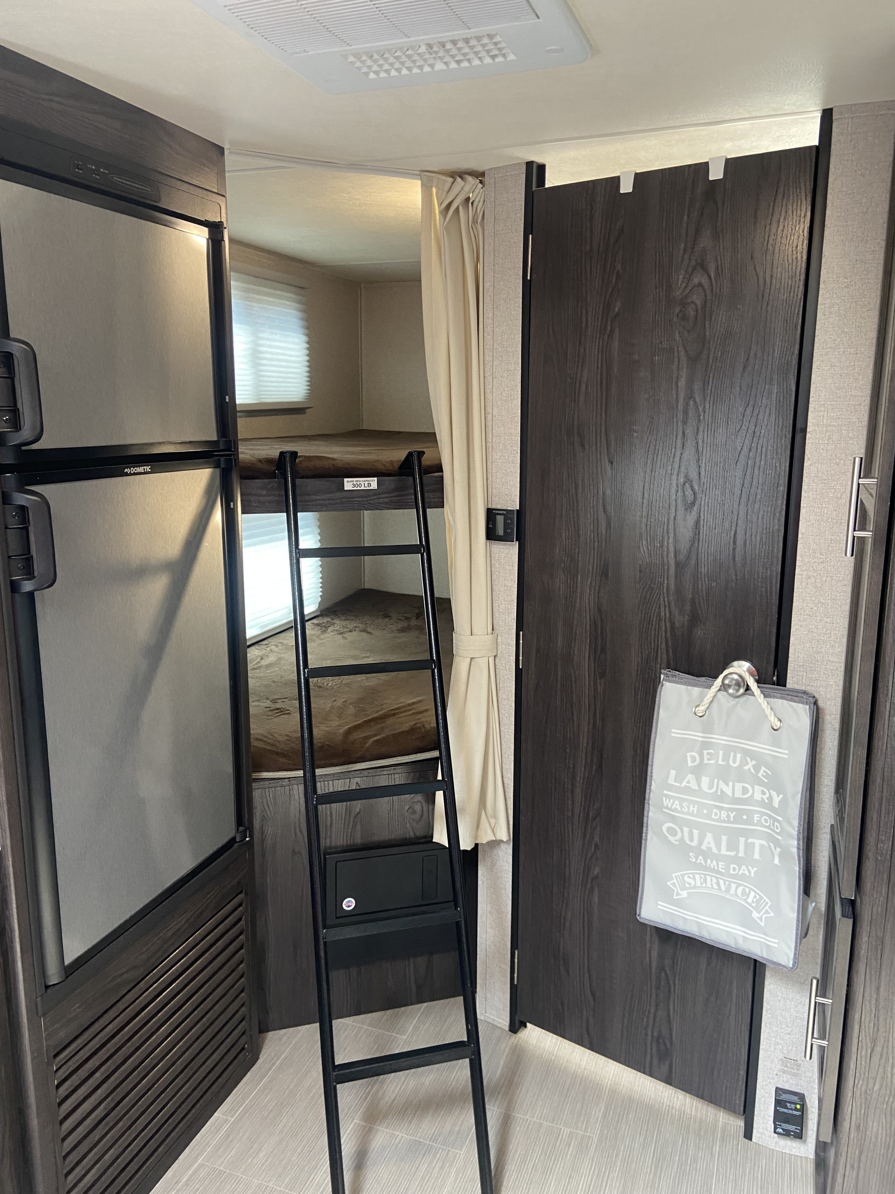 Inside an RV rental: Bunk beds (300lb cap), Dometic fridge, and laundry bag make travel easy.. Dutchmen Other 2018