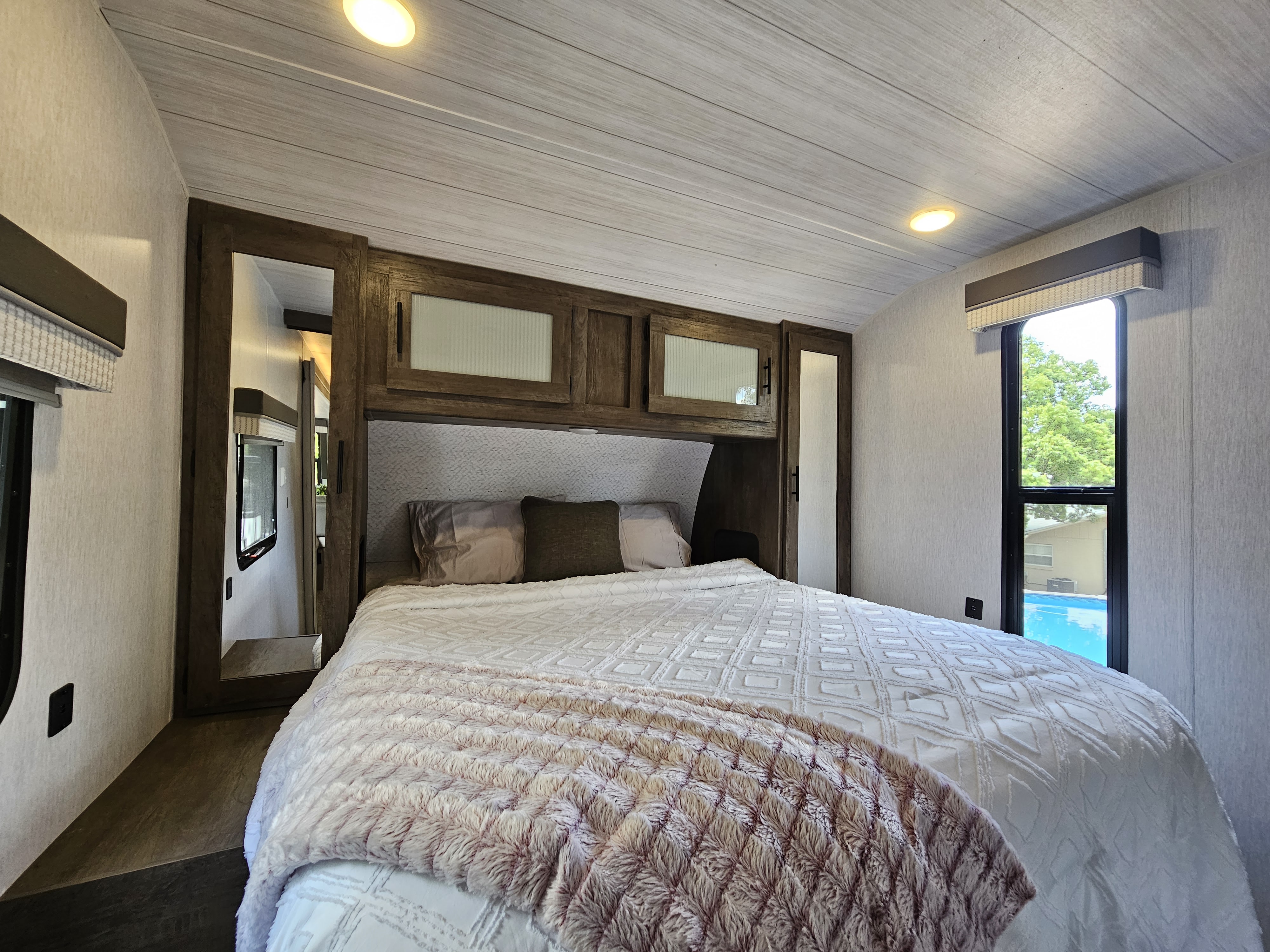 Comfortable RV rental bedroom with spacious bed, ample storage, and large window offering scenic views for your travels.. Forest River Salem 2022