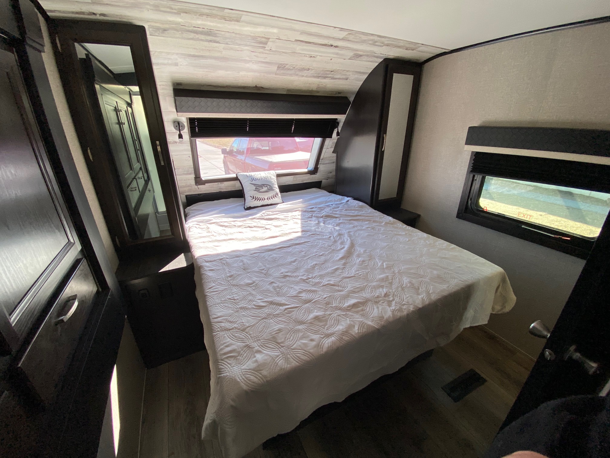 Spacious RV rental bedroom with comfortable bed, ample storage, and natural light from large windows.. Jayco White Hawk 2020