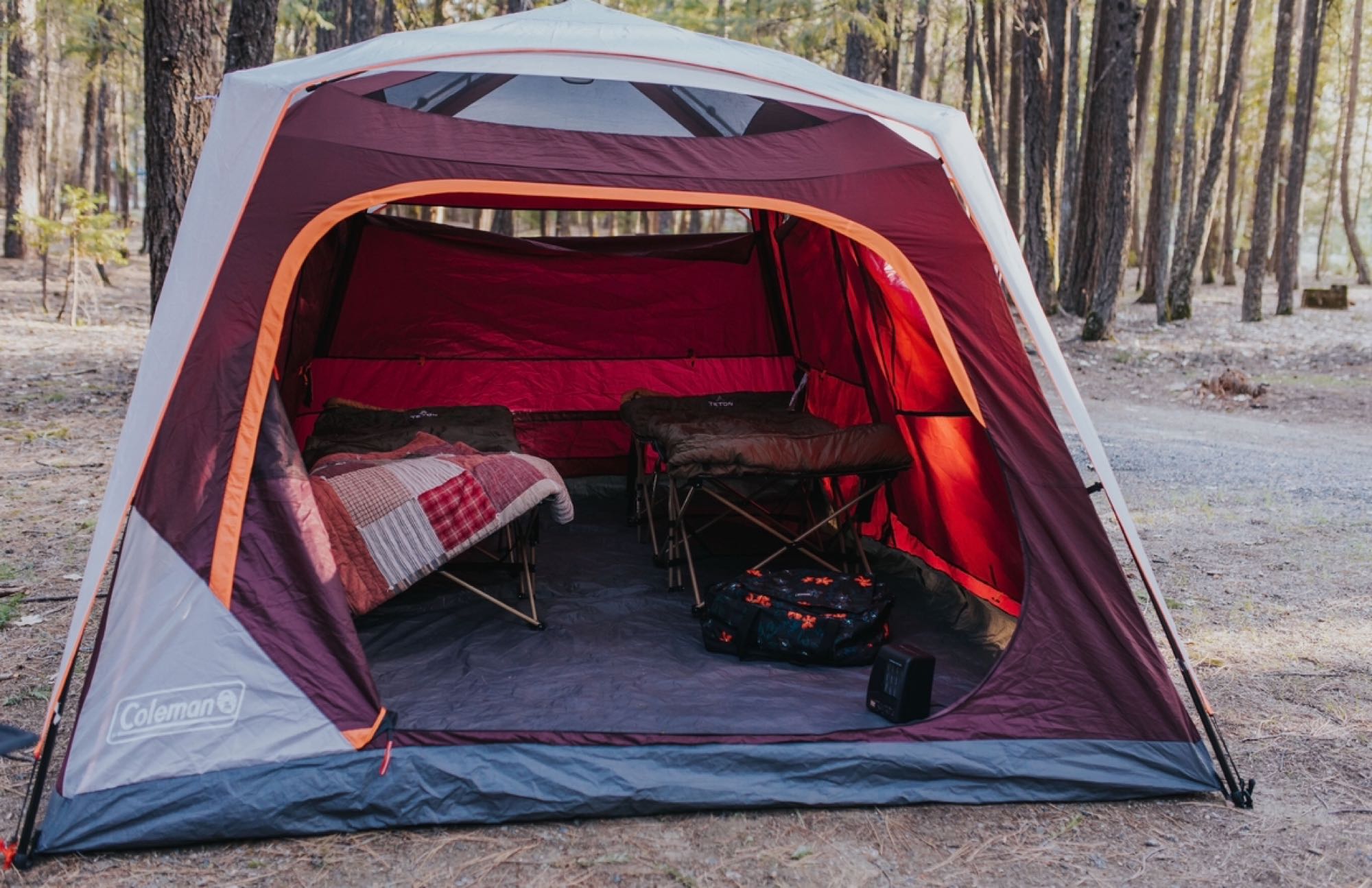 Cozy Coleman tent with cots and heater, nestled in a forest. Experience comfortable camping on your next RV rental adventure.. Quality Cargo 6x10 SA 2022
