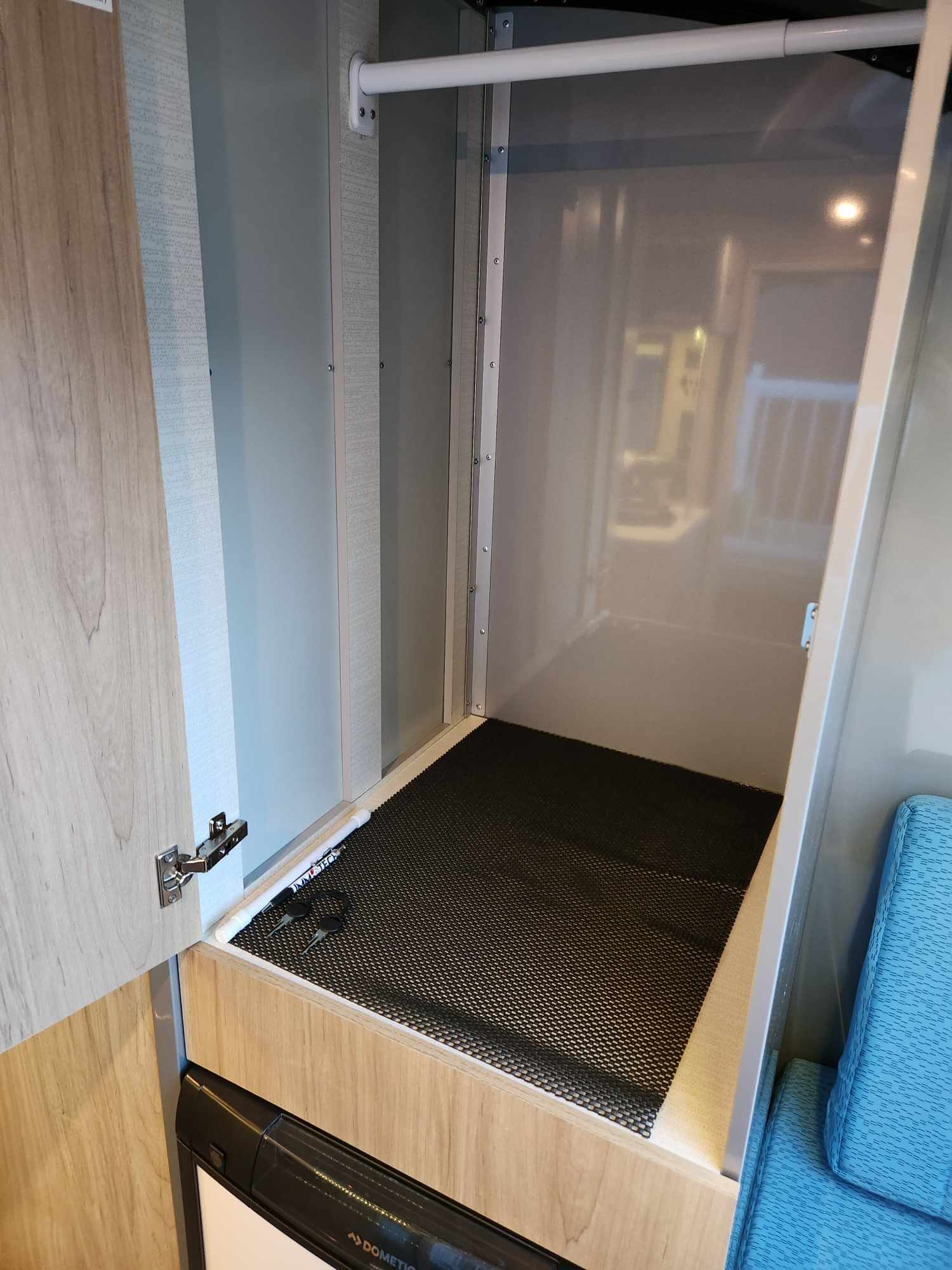 This RV rental features a practical closet with hanging rod, non-slip mat, and space for essentials. Dometic fridge below.. Safari Alto F1743 2024