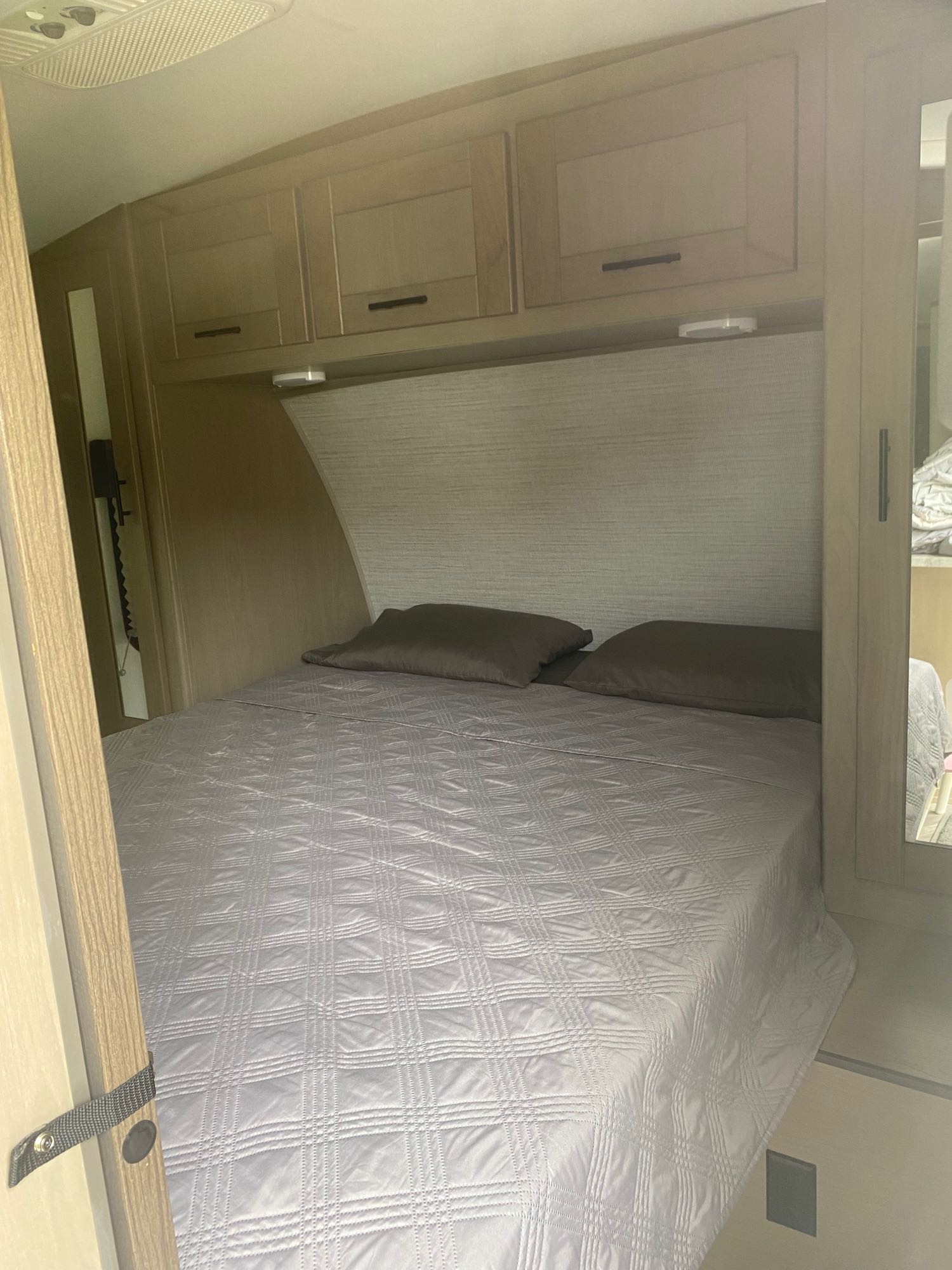 Cozy RV rental bedroom with a comfortable bed, convenient overhead cabinets, and reading lights.. Cruiser RV Shadow Cruiser 2021