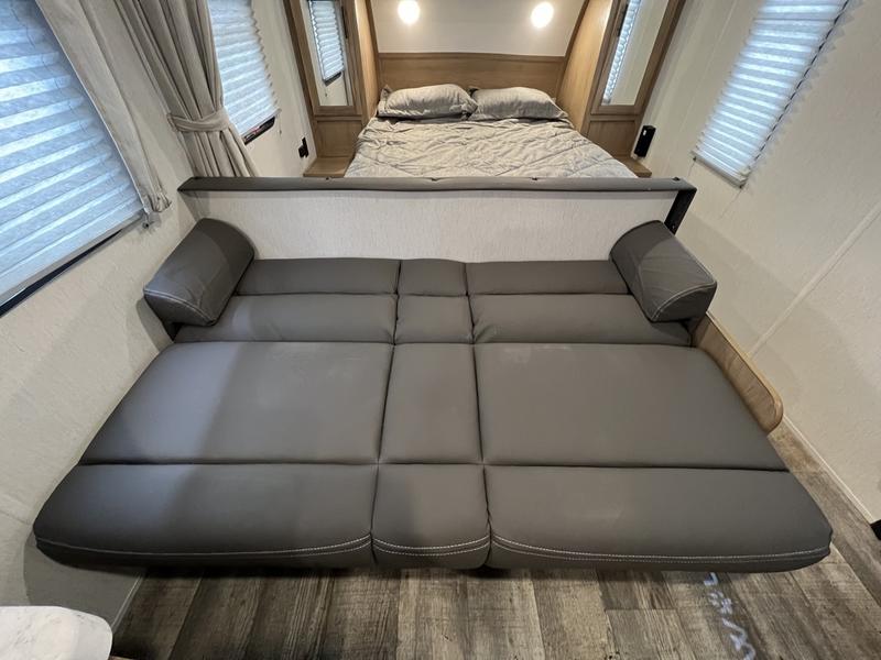 Inside an RV rental: a plush bed and a convertible sofa-bed, maximizing sleeping space for guests.. Forest River Cherokee Grey Wolf Special Edition 2022