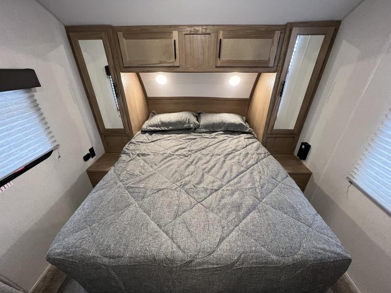 Cozy RV rental bedroom with gray bedding, overhead storage, and mirrored closets.. Forest River Cherokee Grey Wolf Special Edition 2022