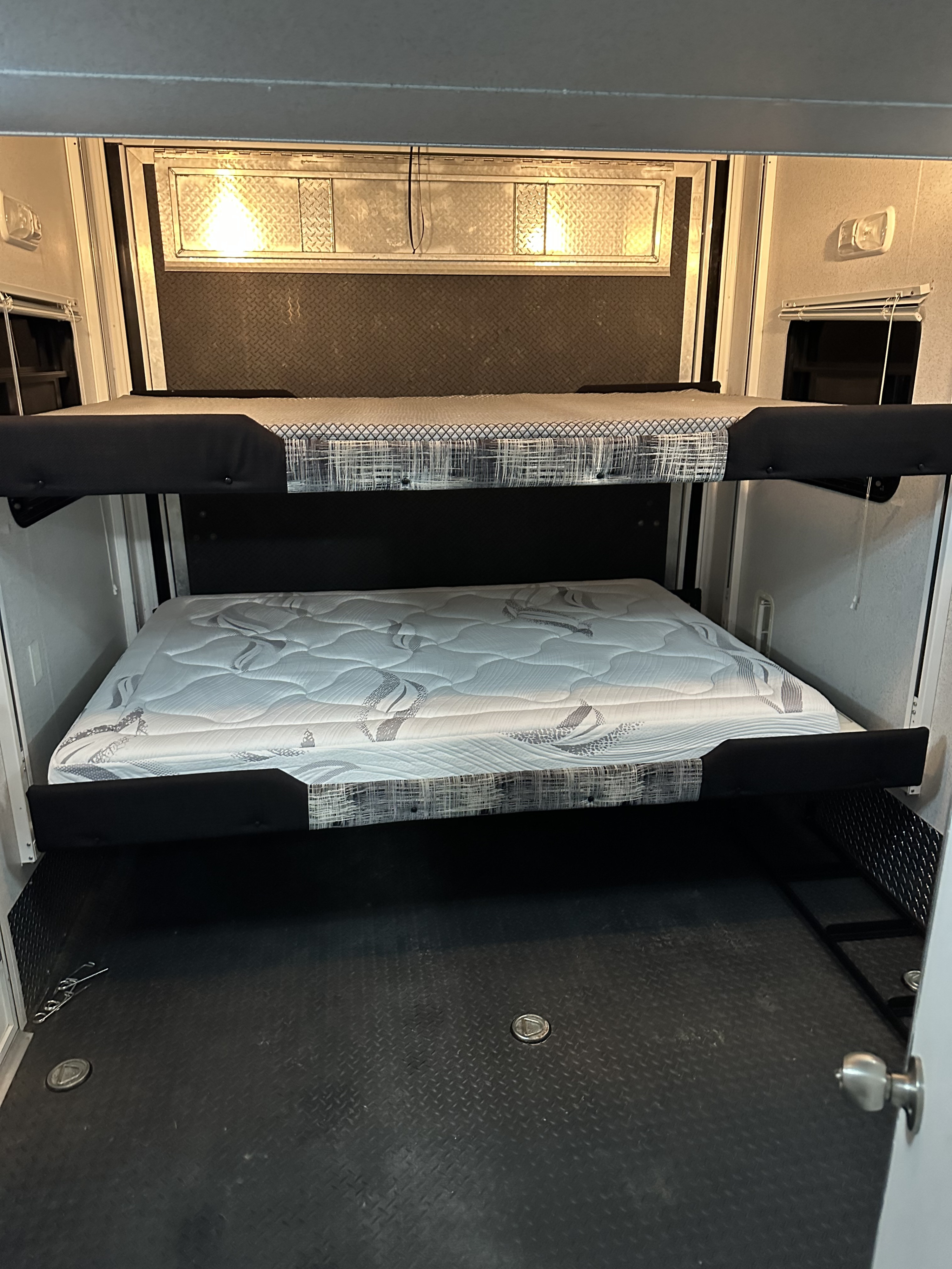 RV rental: Toy hauler interior with a lower mattress-ready bunk and an upper folded bunk. Diamond plate details on walls & floor.. Sportsman M-40P 2008