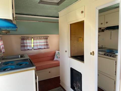 Cozy vintage RV rental interior with compact kitchen and living area.. Concord Vintage 1973