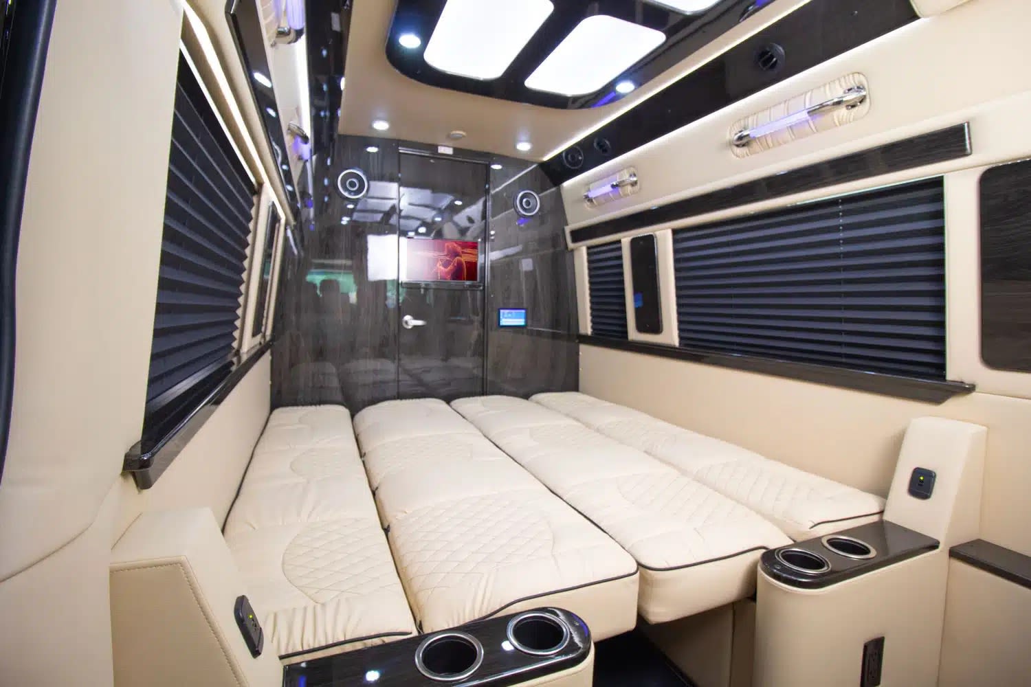 Inside a luxury RV rental: spacious interior with four cream sleeping berths, screens, & window blinds for comfortable travel.. Ultimate Toys Ultimate Traveler 2024