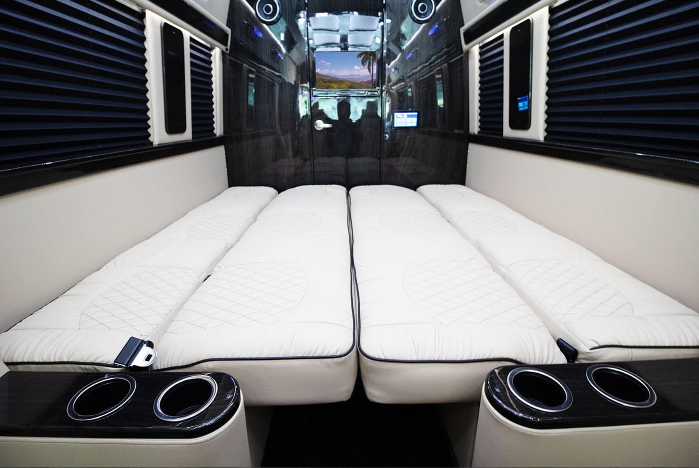 Luxury RV rental interior: Four plush white quilted beds, modern black trim, and amenities offer ultimate travel comfort.. Ultimate Toys Ultimate Traveler 2024