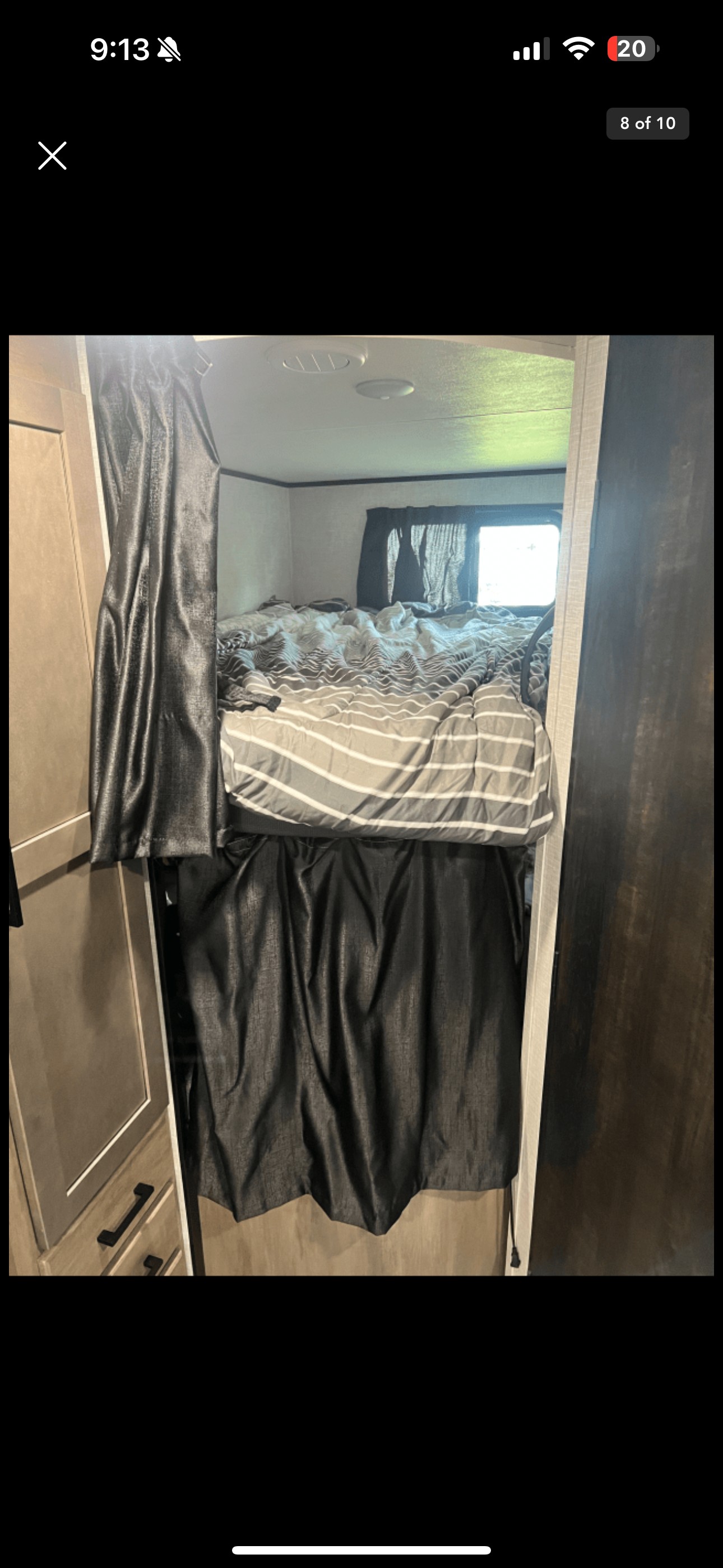 Inside an RV rental, showing a bunk bed setup with striped bedding and dark privacy curtains.. Jayco 284bhs 2024