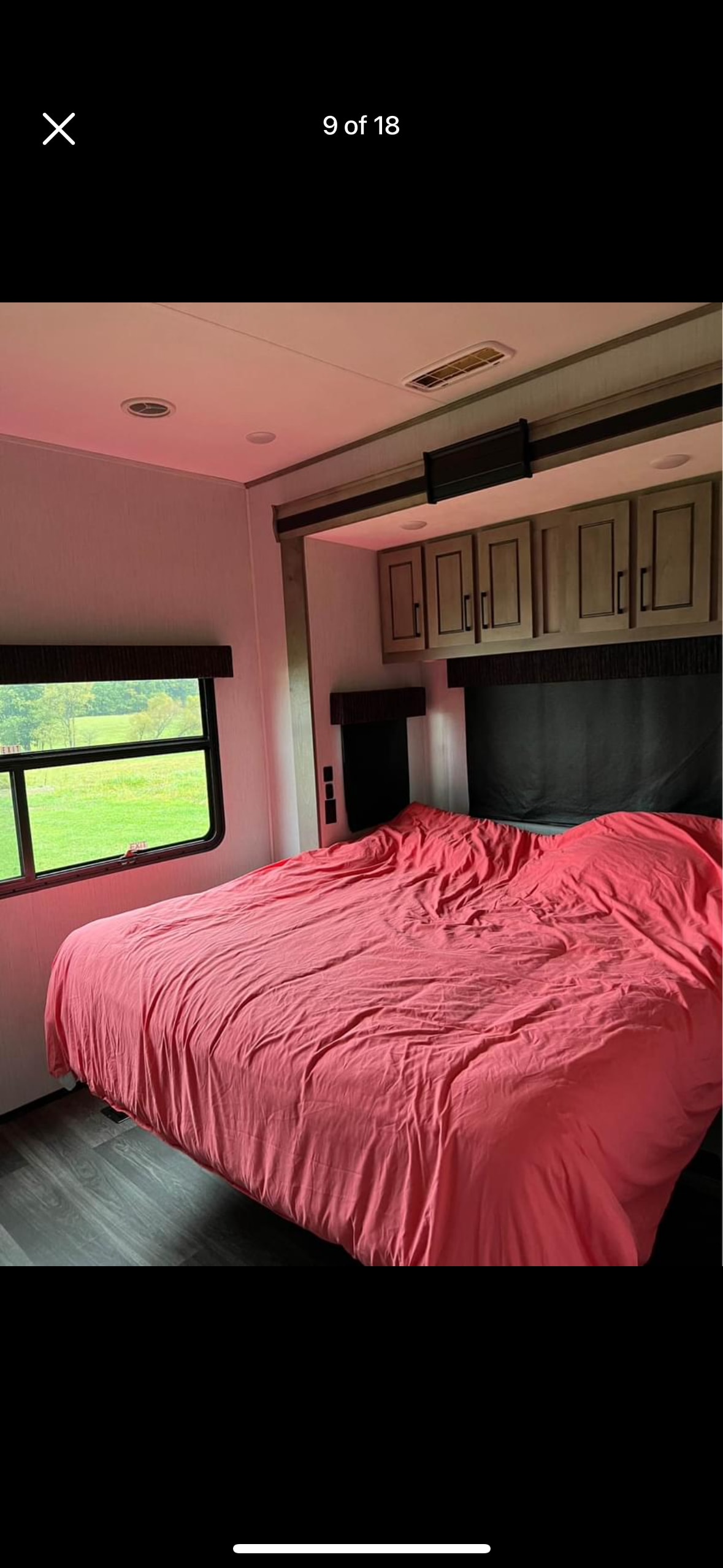Spacious RV rental bedroom featuring a comfy bed, overhead cabinets, and a picturesque window view.. Heartland RVs Big Country 2021