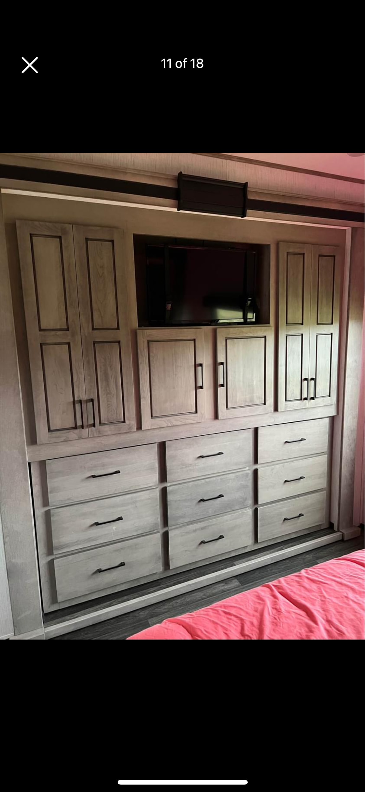 RV rental bedroom with built-in storage: TV, light gray cabinets, and drawers. Pink bedding visible.. Heartland RVs Big Country 2021