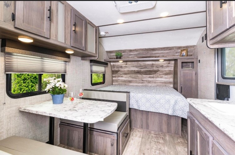 Cozy RV rental interior with a bed, dinette, and ample storage, designed for comfortable travel and adventure.. Gulf Stream Ameri-Lite Super Lite 2022