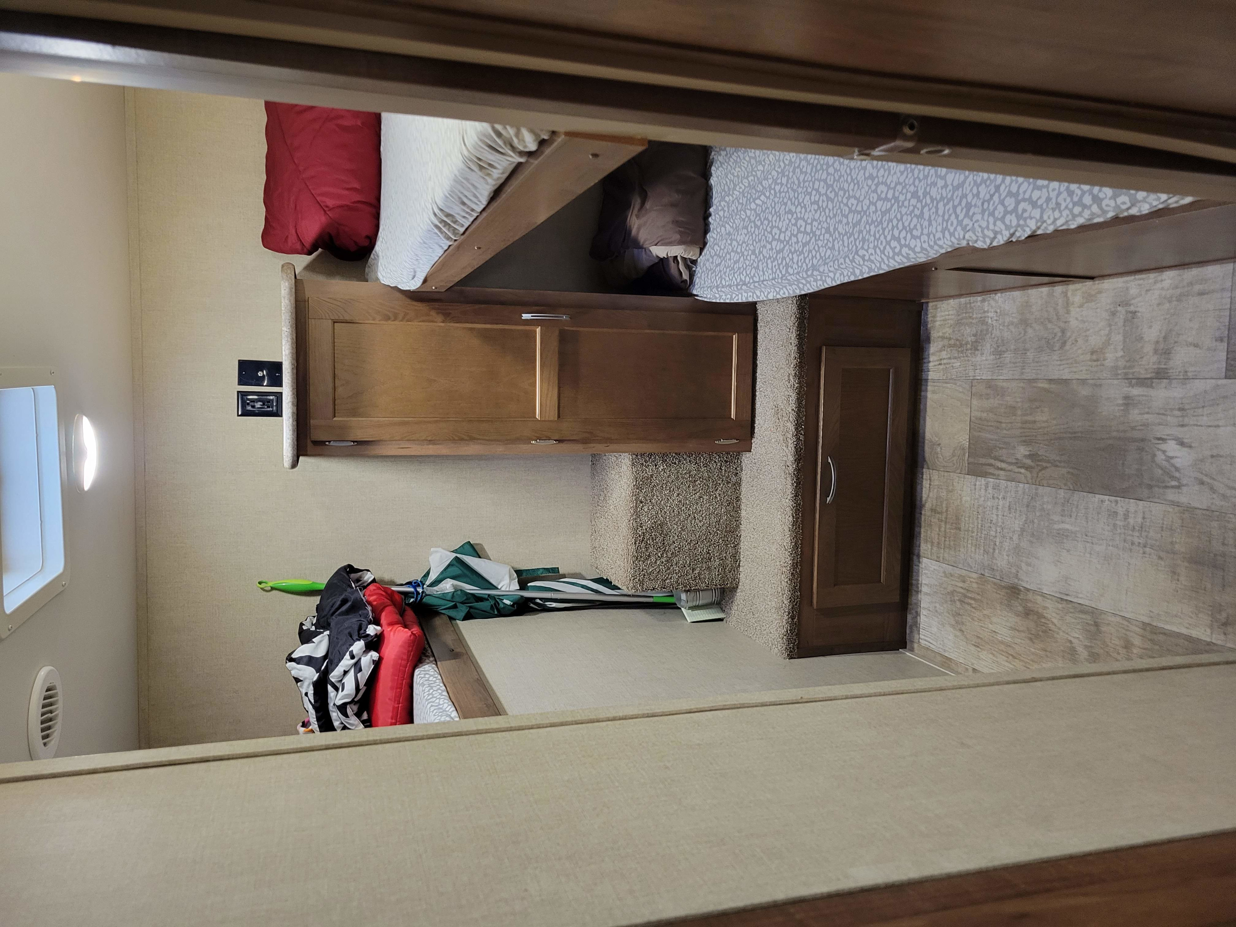 Compact RV rental bunk bed area with wooden cabinetry, carpeted steps, and outlets, offering a cozy sleeping space.. Gulf Stream Kingsport 2018
