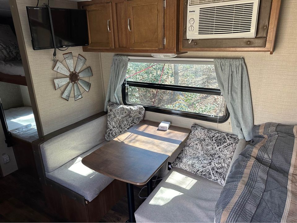 Inside this RV rental: a cozy dinette, bunks, and AC. Enjoy comfortable camper living on your next trip.. Keystone RV Summerland Mini 2017