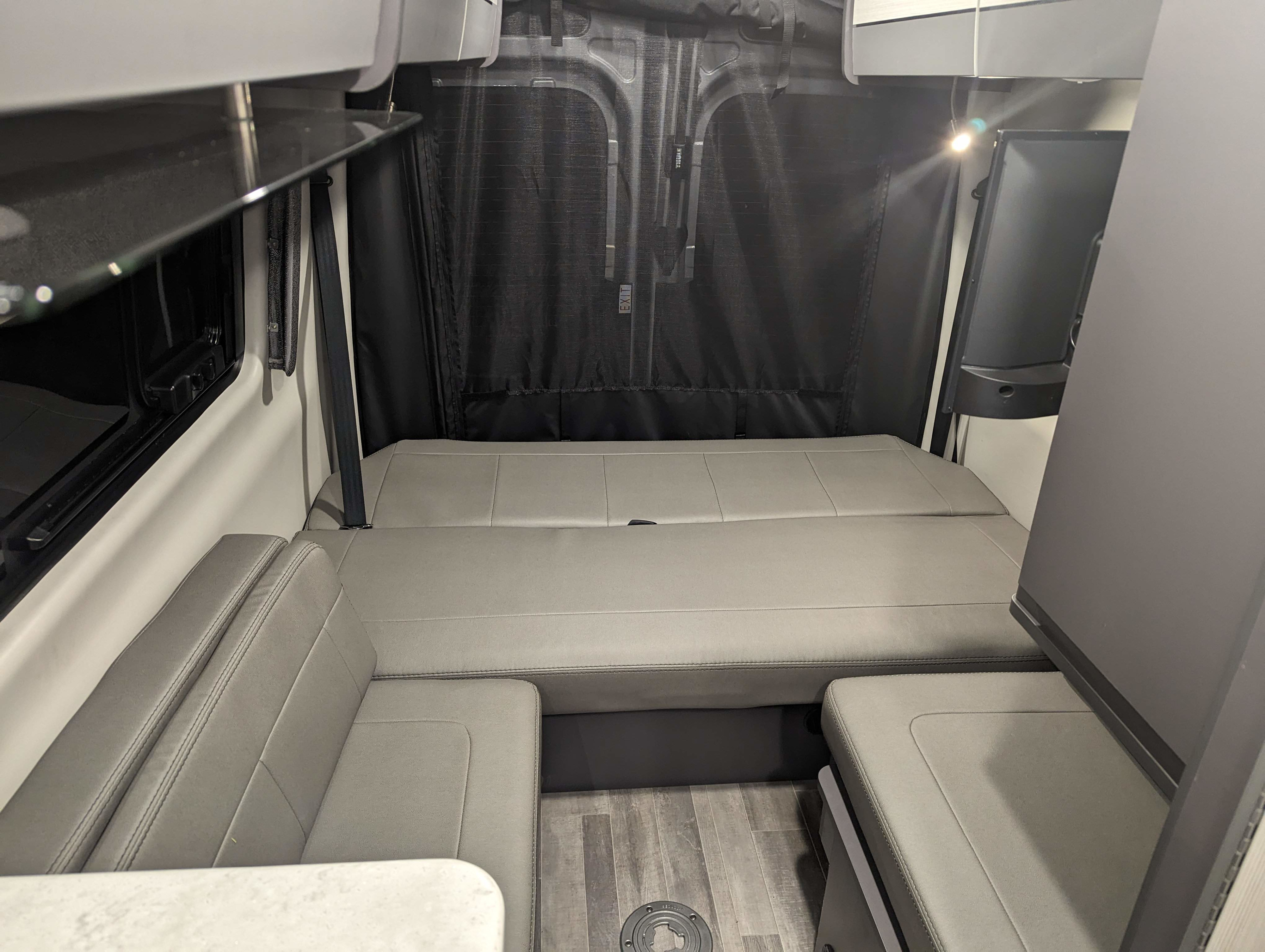 RV rental interior: A versatile bed/lounge area, side seating, and rear privacy screens create a comfortable space for travel.. Thor Tranquility 2023