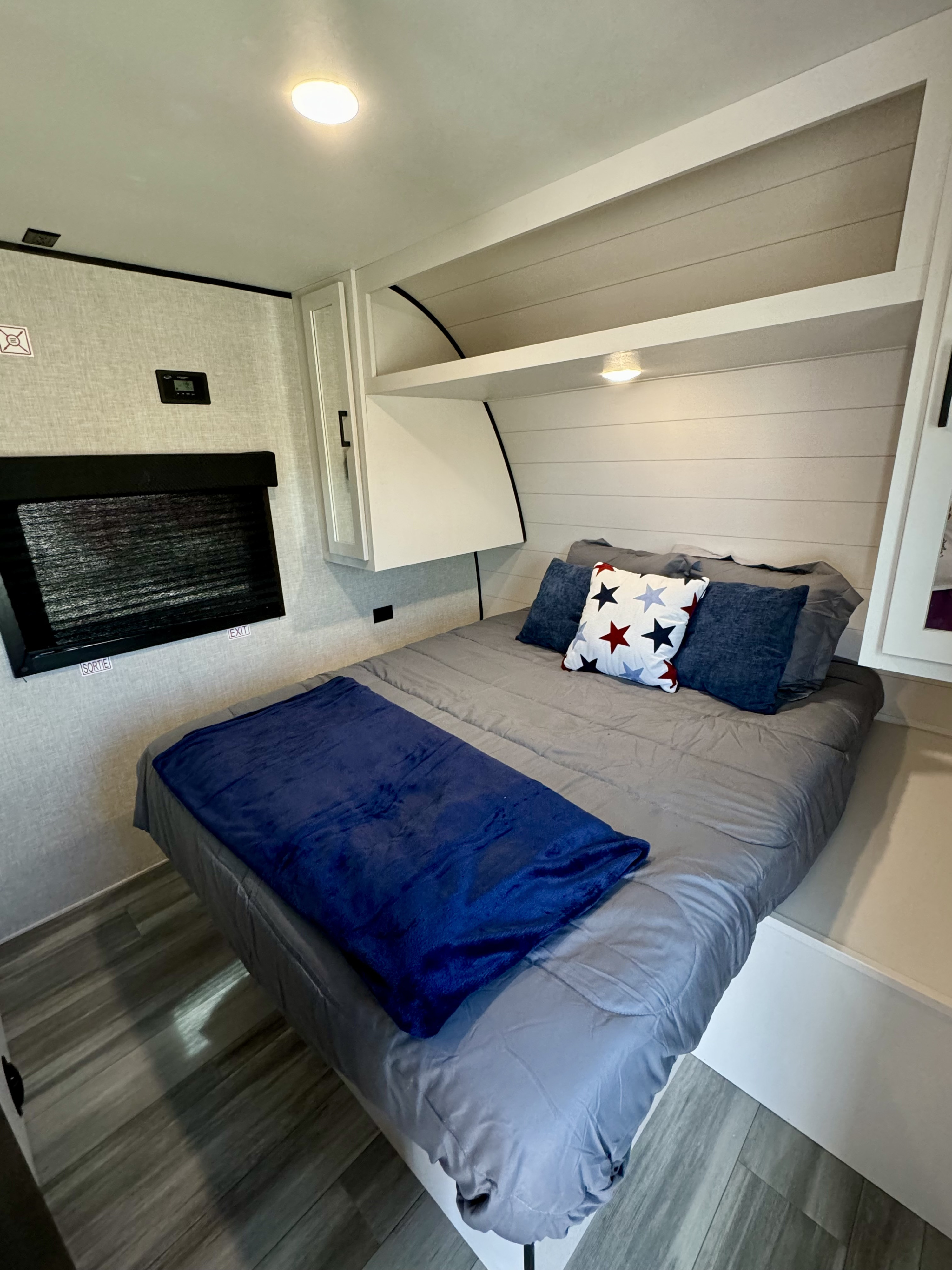 Cozy RV rental bedroom with a comfortable bed, smart storage, and modern finishes, perfect for a restful journey.. Wayfinder GoPlay 26BH 2024