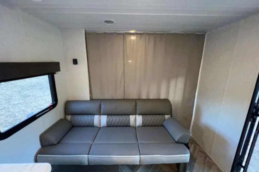 RV rental: Bright interior with a gray sofa/bed, window, and privacy curtains.. Forest River 268bh 2022