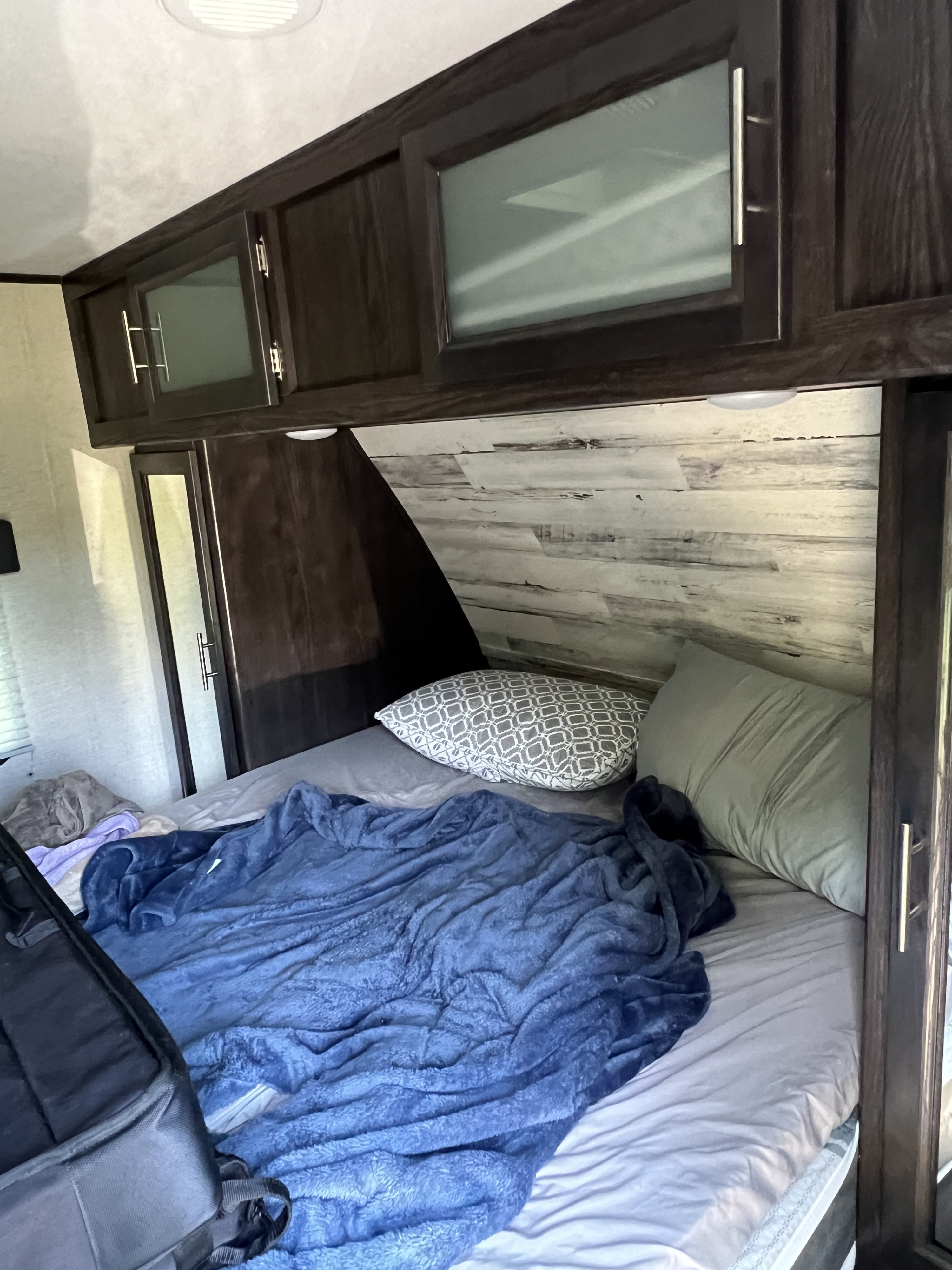 Queen size bed with foam topper in master bedroom.  Has sliding door and private entrance for privacy from main cabin.. Dutchmen Kodiak Ultra Lite 2020