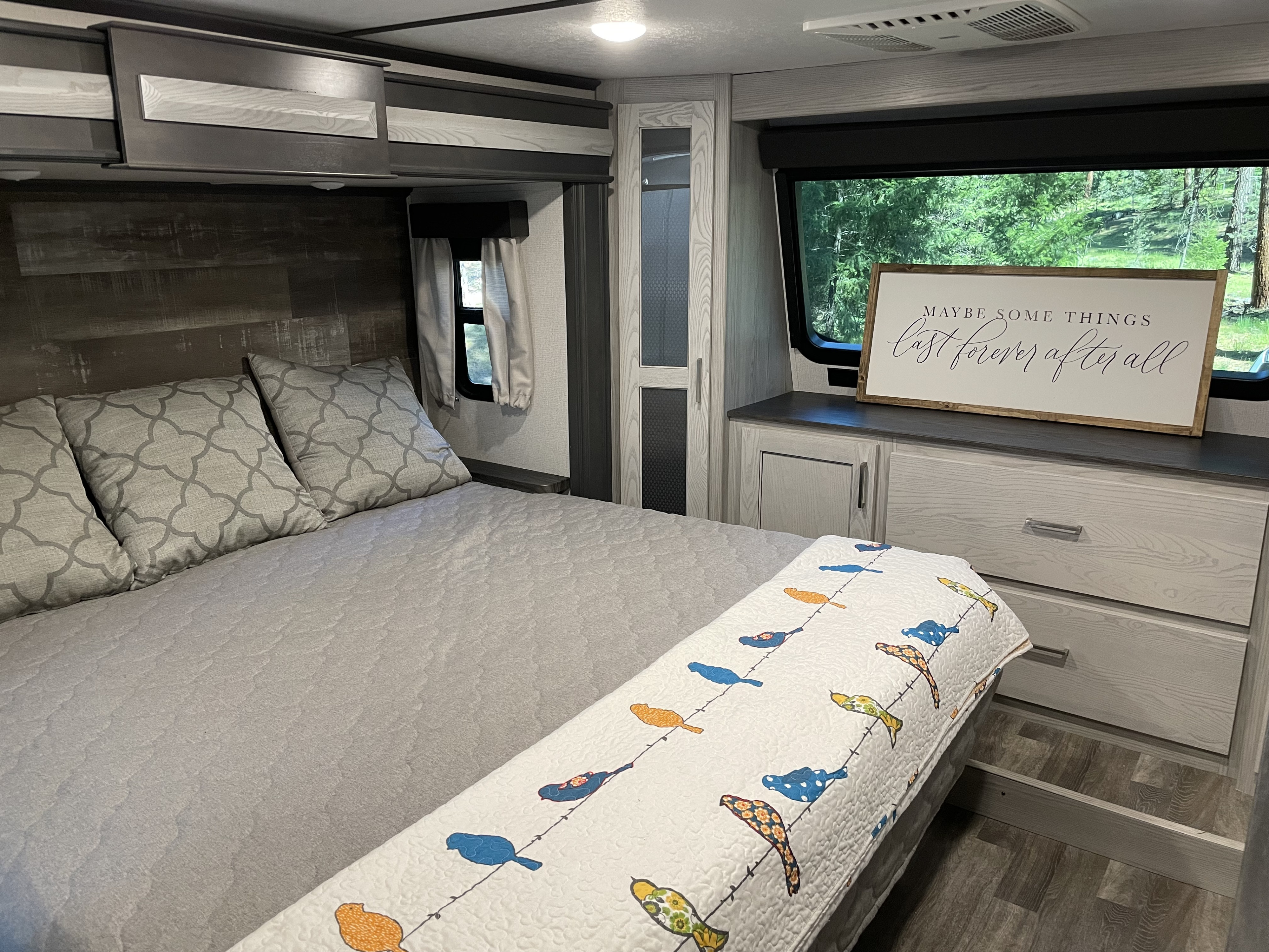 Modern RV rental bedroom with a comfy bed, stylish storage, and nature views. Ideal for a relaxing journey.. Keystone RV Montana High Country 2021