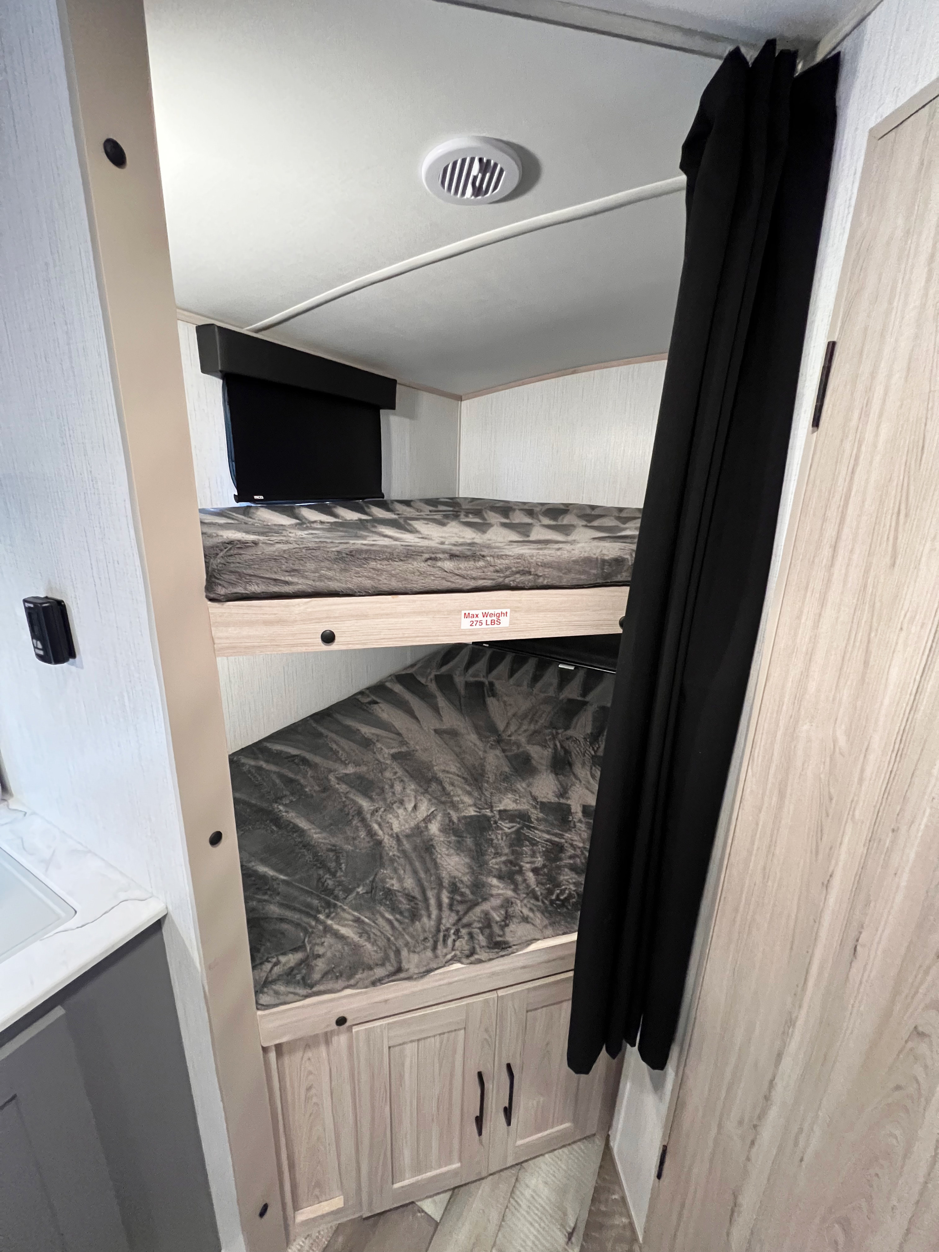 RV rental features stacked bunk beds, a compact sleeping area with a privacy curtain. Max weight 275 lbs.. Heartland Sundance 2022