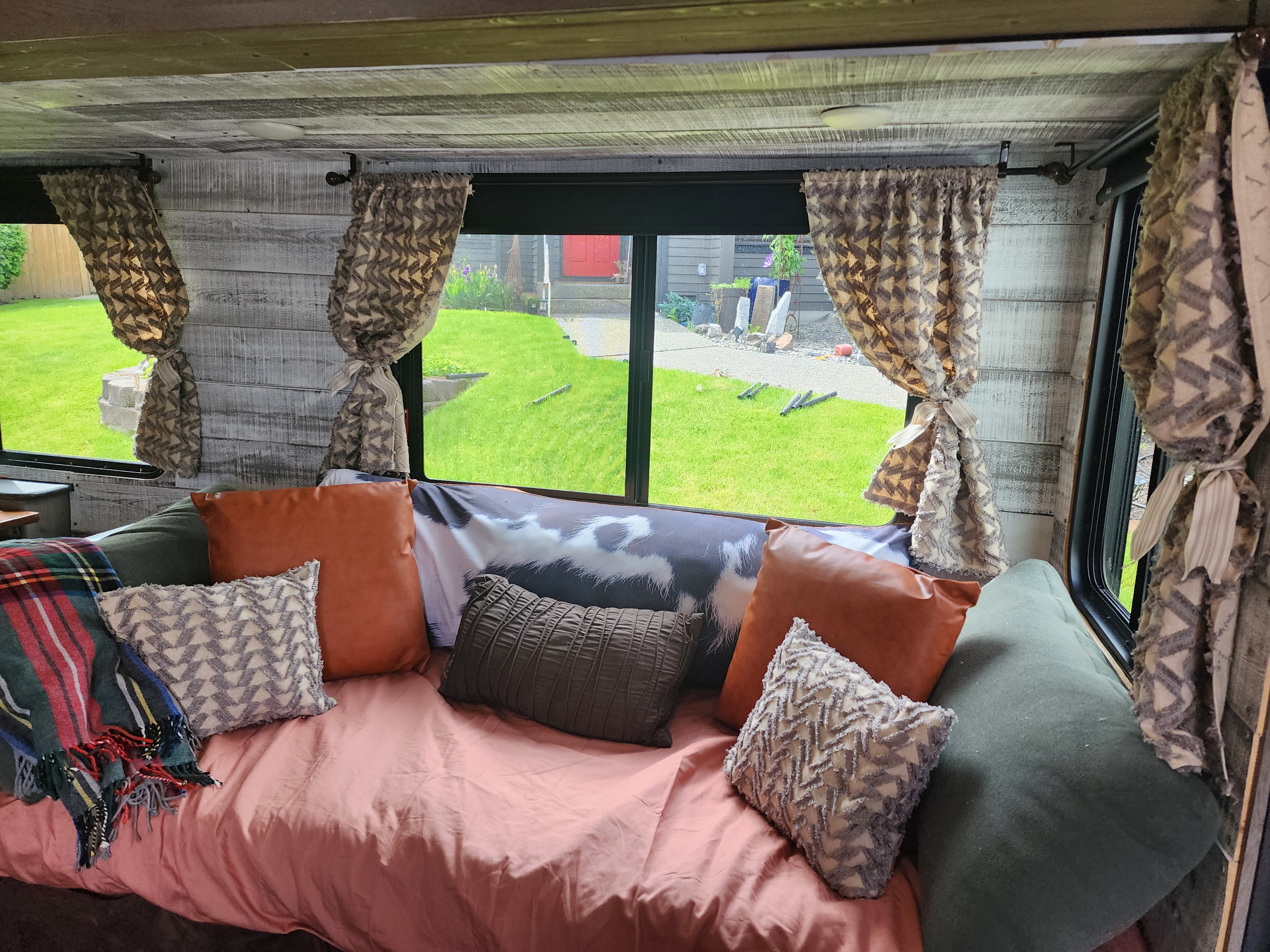 Experience comfort in this RV rental's inviting interior: plush couch, patterned pillows, and a clear view of the outdoors.. Keystone Outback 2019