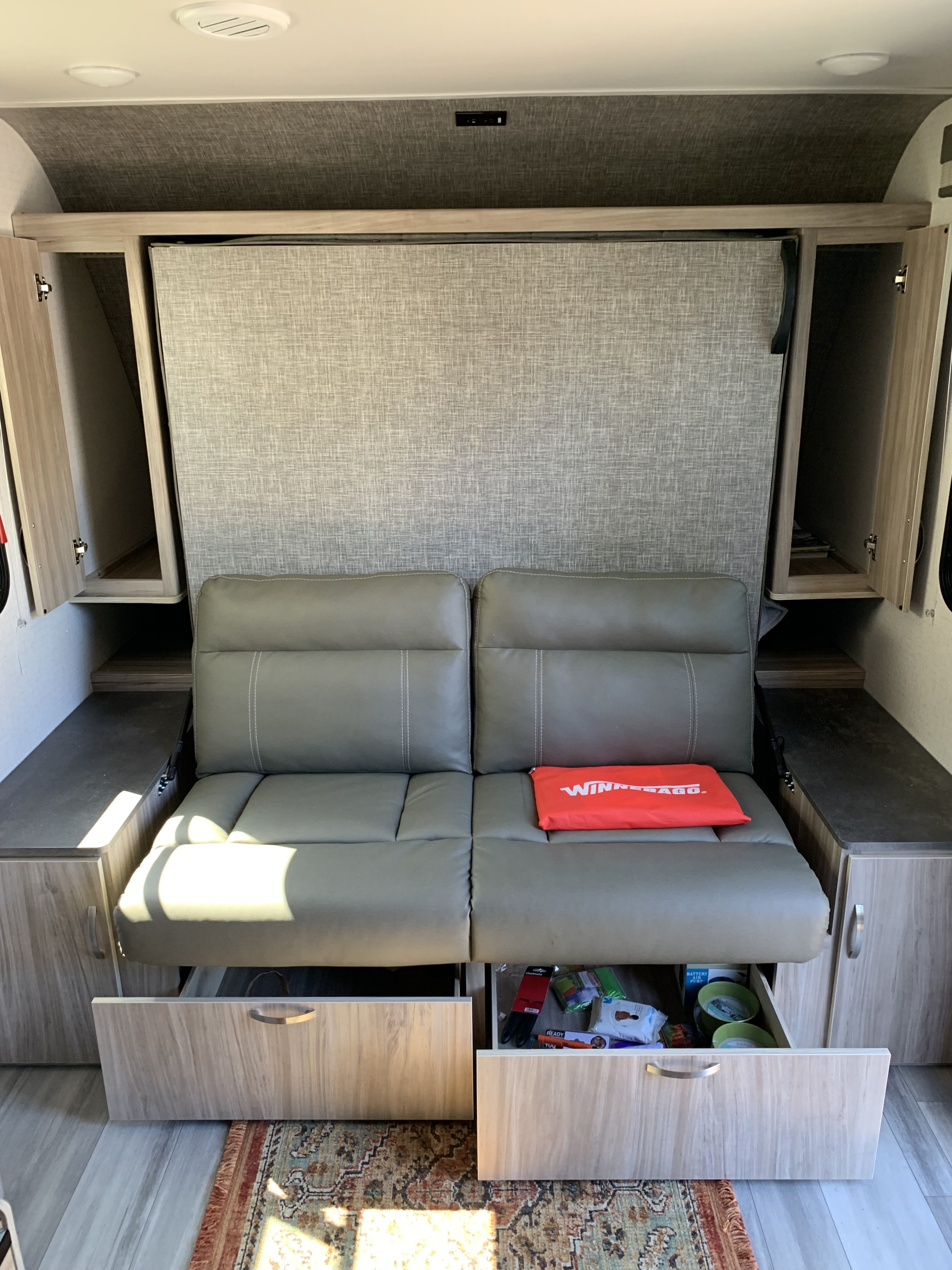 RV rental interior: sofa with hidden wall bed, handy side cabinets, and open storage drawers.. Winnebago Micro Minnie 2306BHS 2022