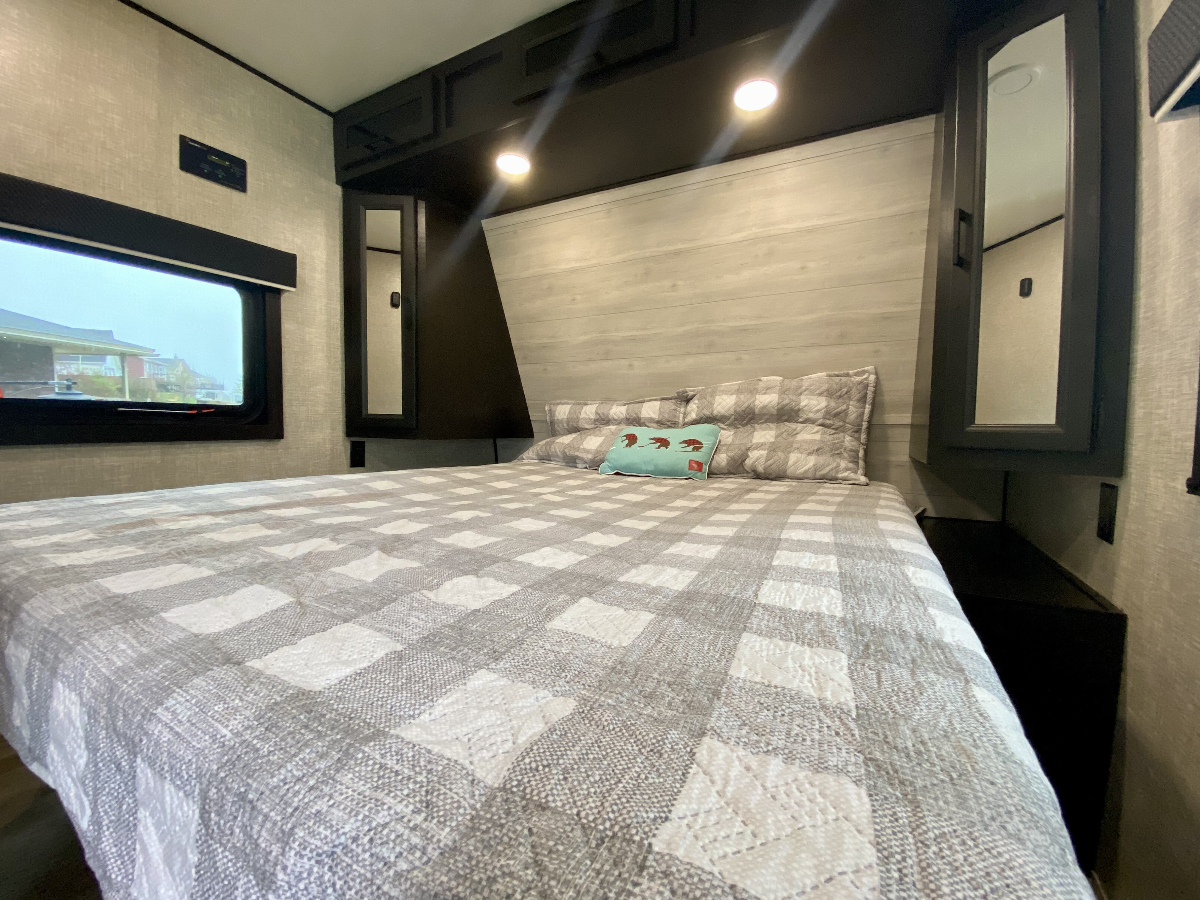Cozy RV rental bedroom with plaid bed, window, and storage. Perfect for road trips!. Jayco Jay Flight 2022