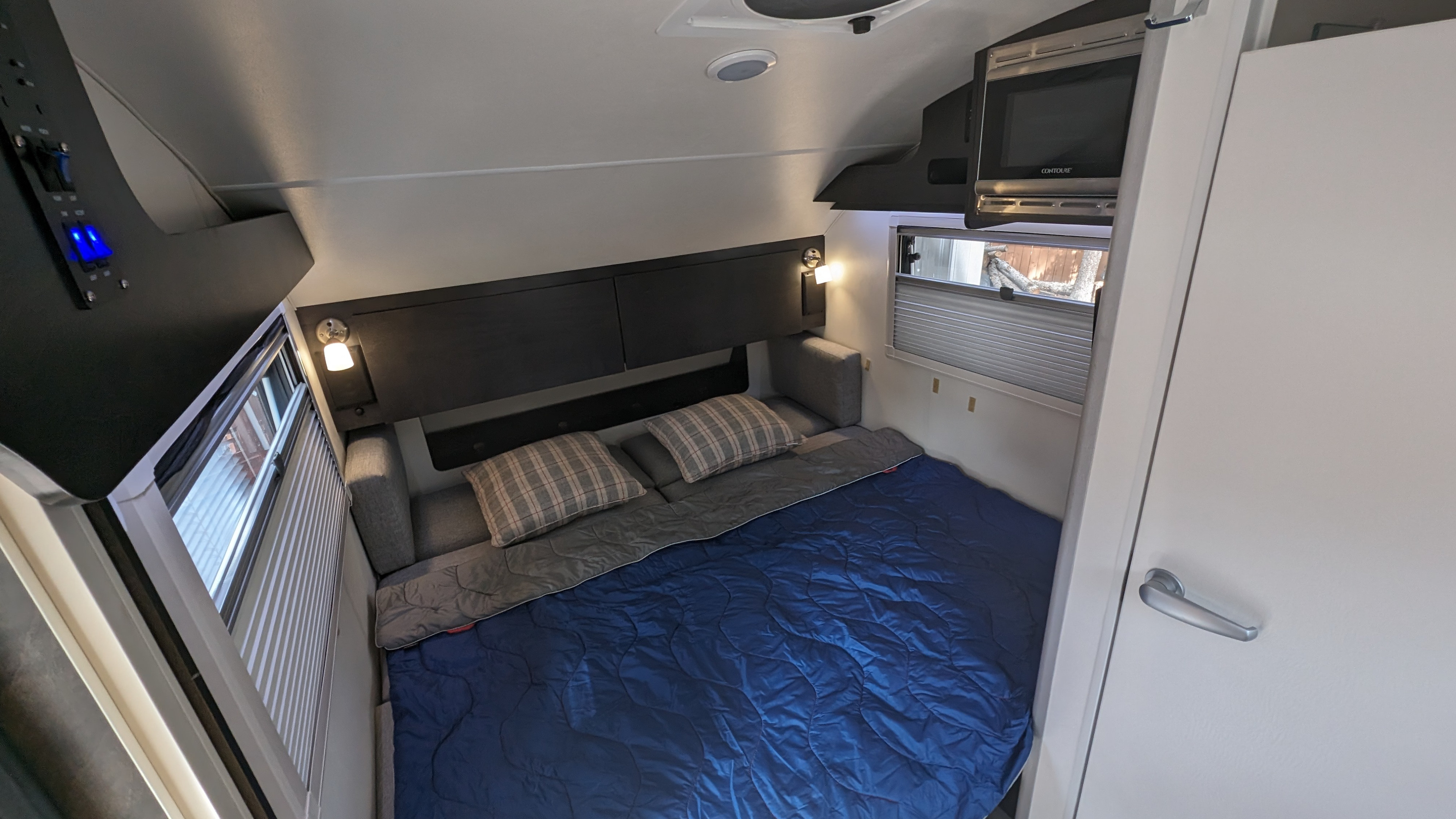 This RV rental offers a compact bedroom with a comfy bed, overhead microwave, and essential controls. Perfect for travel.. nuCamp T@G 2023