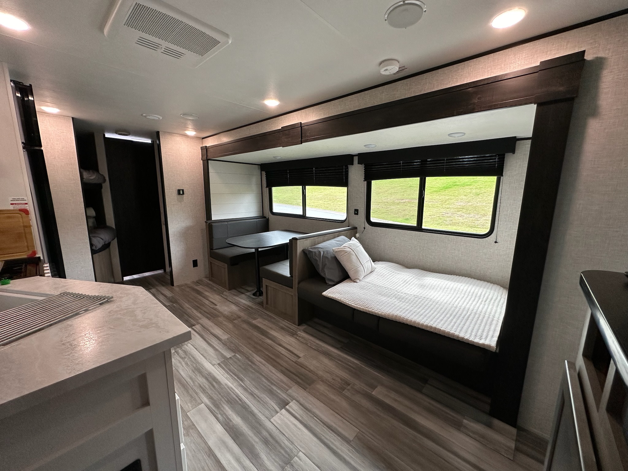 Spacious and modern RV rental interior featuring a dinette, comfy sofa bed, and kitchen counter. Perfect for travel.. Jayco Jay Flight SLX 2024