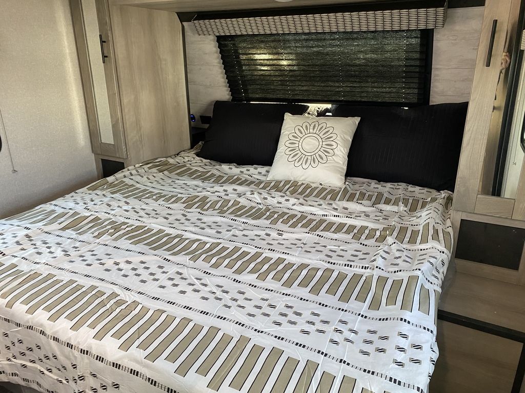 Cozy RV rental bedroom features a full bed with patterned bedding, black pillows, and compact mirrored storage.. KZ KZ CONNECT C241RLK 2022