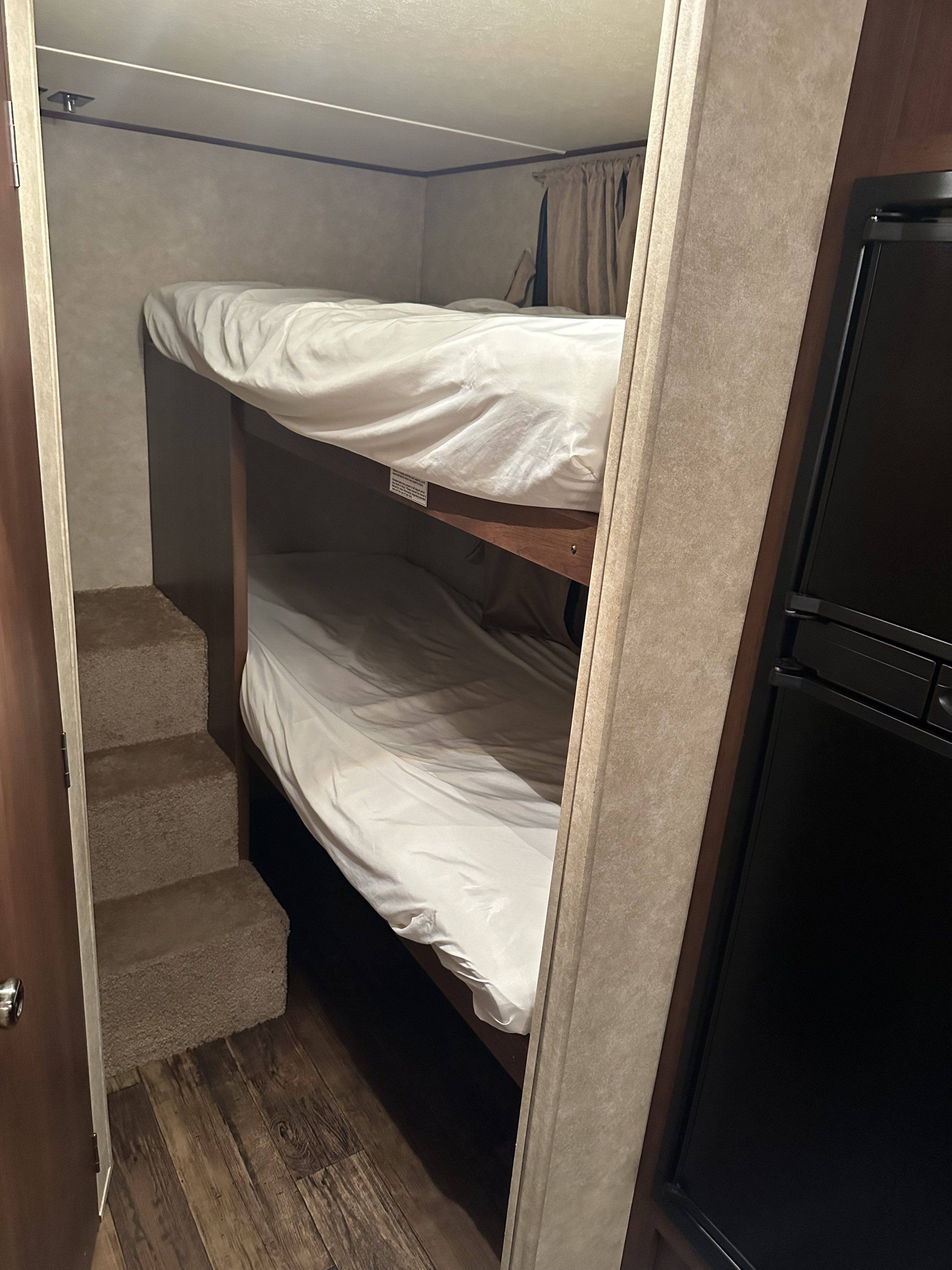 Cozy RV rental interior with comfortable bunk beds, built-in steps, and a refrigerator for your travels.. Crossroads RV Z-1 2013