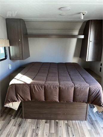 Cozy RV rental bedroom with a comfy bed, overhead storage, and window. Perfect for your next adventure.. Keystone RV Hideout LHS Mini 2020