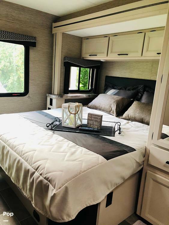 Cozy RV rental bedroom with a comfortable bed, overhead storage, and windows for natural light, perfect for travel.. Thor Motor Coach Chateau 2022
