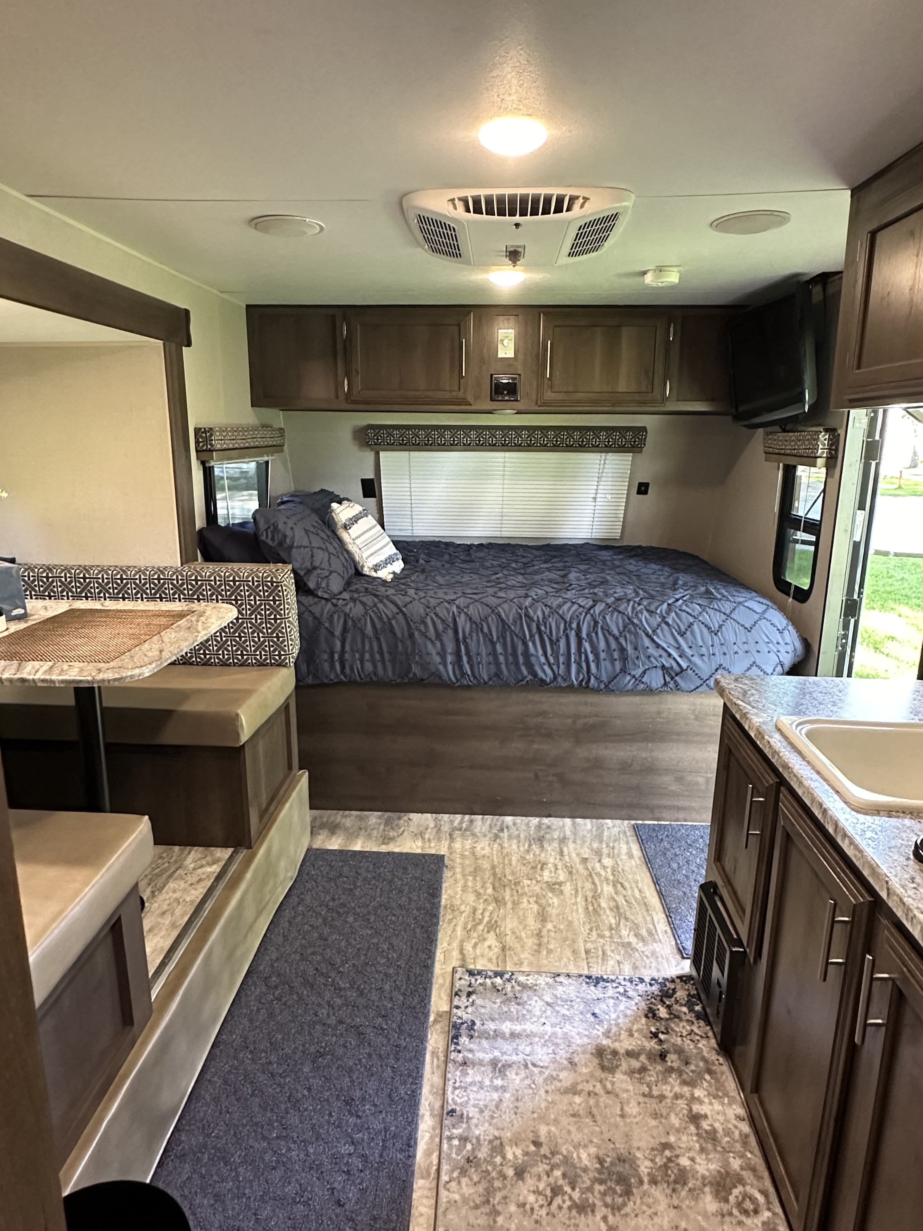 Spacious RV rental interior featuring a cozy bedroom, dinette, and kitchen. Perfect for your next adventure!. KZ Escape 2018