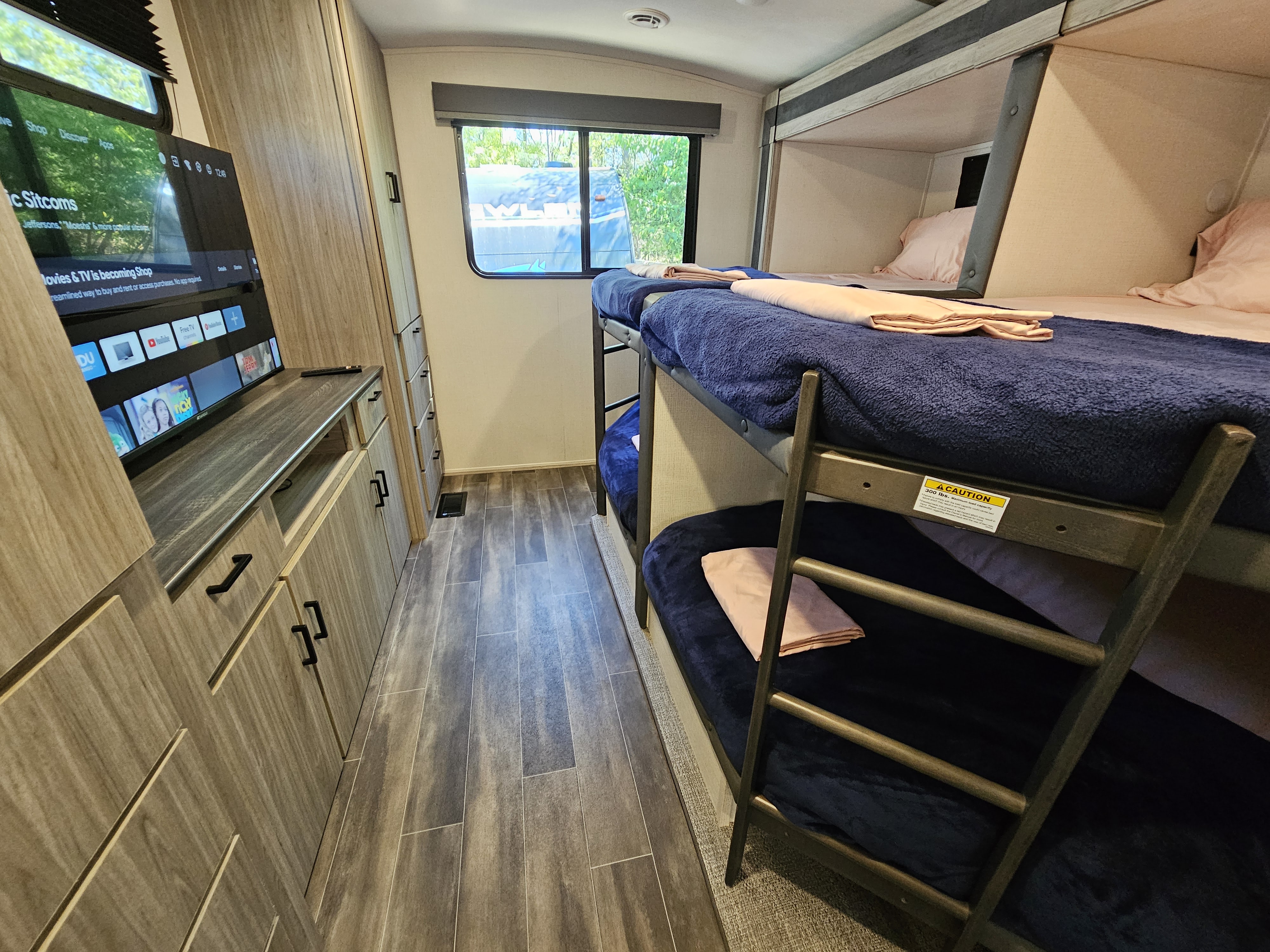 Cozy RV rental interior: bunk beds, entertainment center, and ample storage for a comfortable family trip.. Keystone Passport 2022