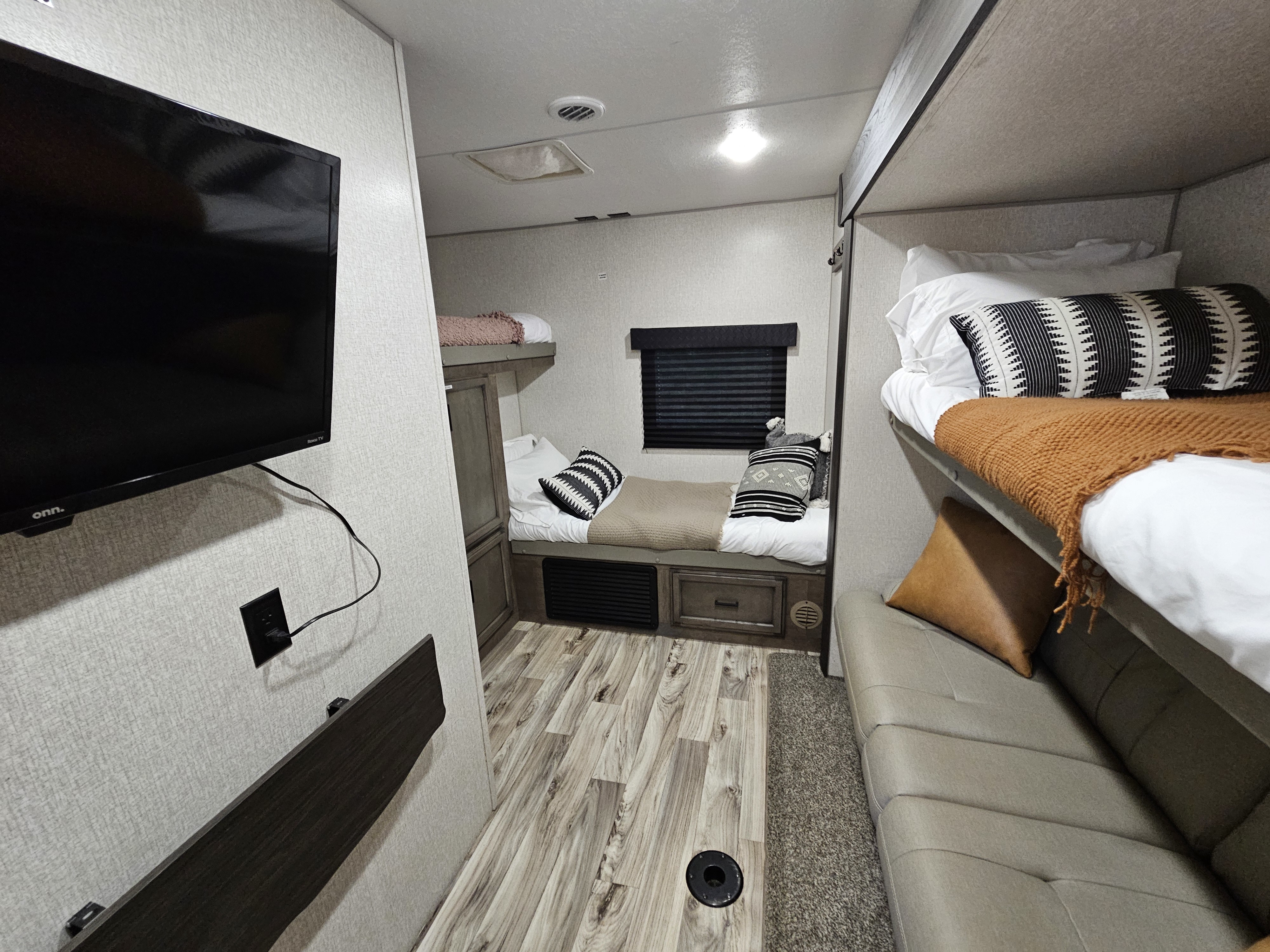 RV rental bunkhouse: multi-level beds, a TV, and sofa. Ready for comfortable family trips.. Venture Rv Sporttrek 2022
