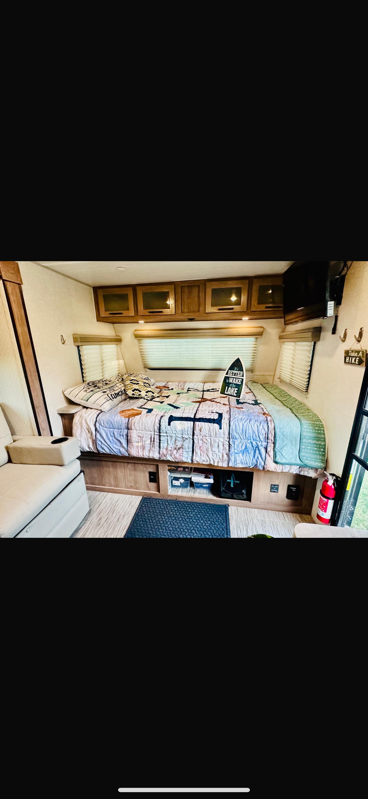 Comfortable RV rental interior: bed, cabinets, TV, seating area. Ideal for travel.. No Boundaries 19.8 2021