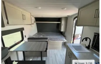 Modern RV rental interior with kitchen, dinette, and comfortable rear bed. Ideal for camping & road trips.. Keystone RV Springdale 2024
