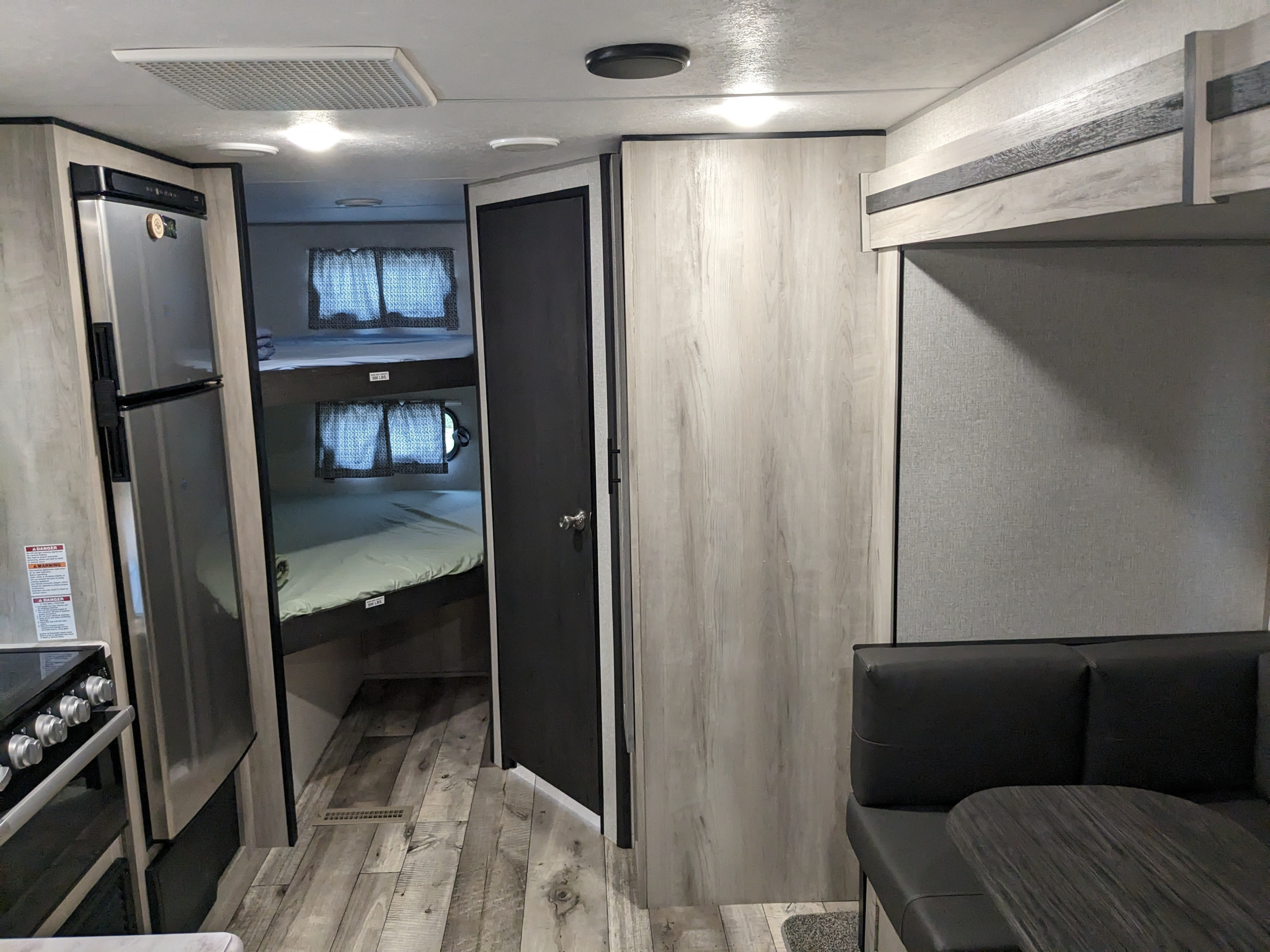 Spacious RV rental interior with kitchen, stainless steel fridge, oven, cozy bunk beds, and a dinette area.. KZ C241bhkse 2022