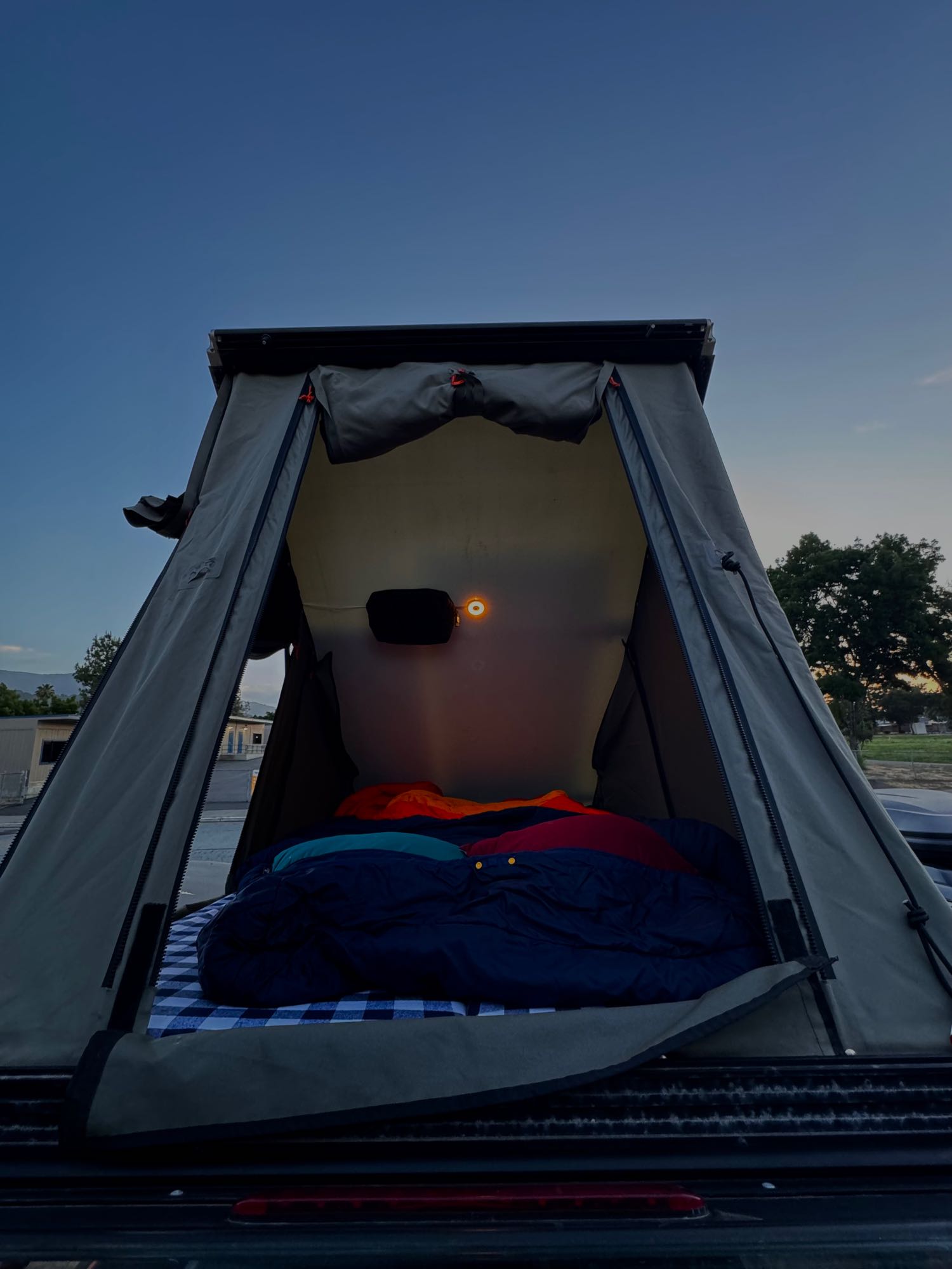 Cozy rooftop tent on a vehicle, perfect for your next RV rental camping trip. Bedding & warm light inside.. Toyota Tacoma - GoFastCamper 2007