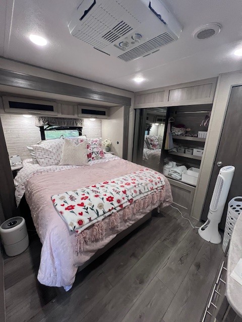 Cozy RV bedroom with pink bedding and decor, perfect for an RV rental getaway.. Forest River Aurora Aurora 2023