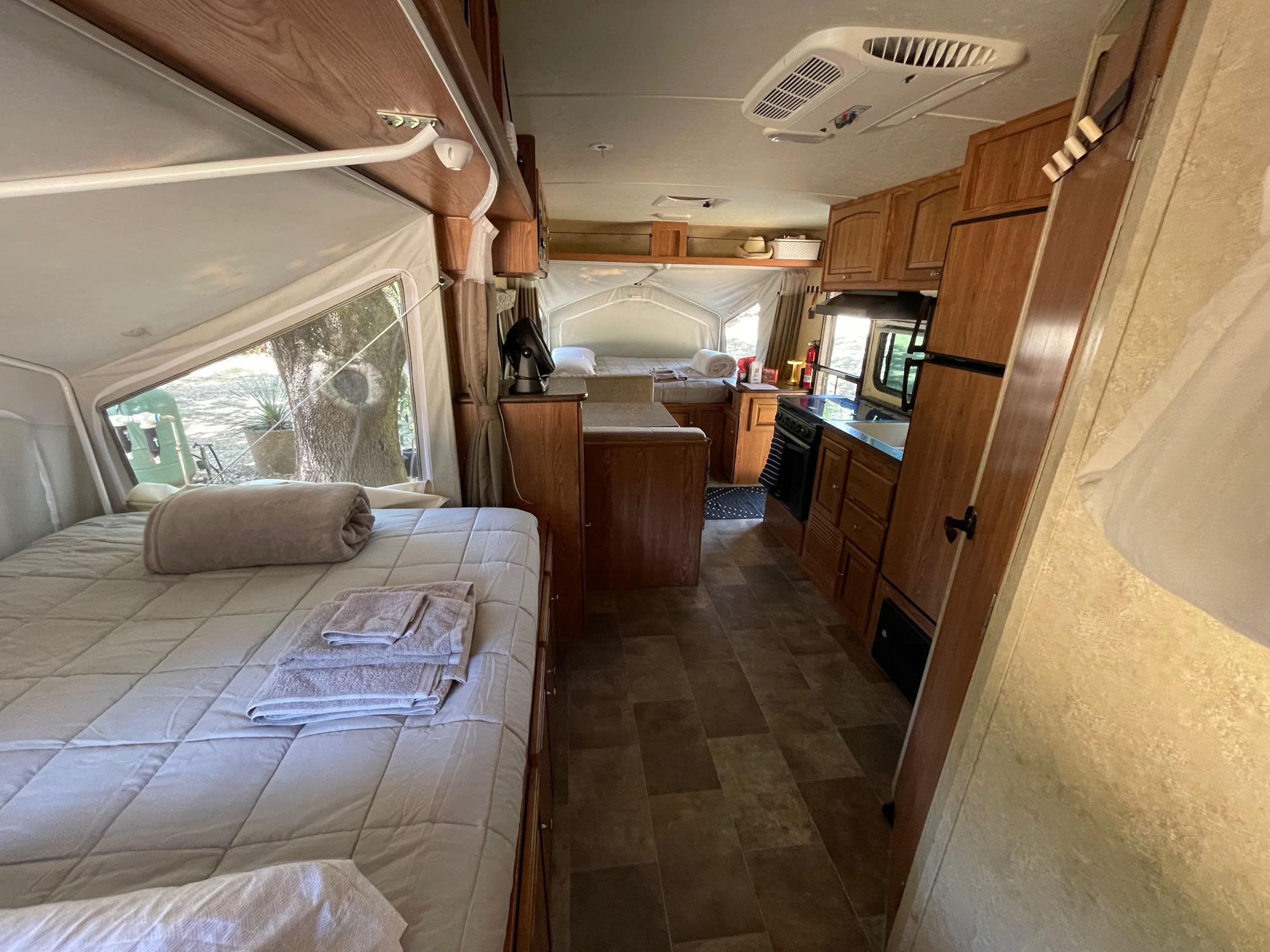 Spacious **rv rental** interior featuring a cozy bed, full kitchen, and ample living space for comfortable travels.. Forest River Flagstaff Shamrock 2015