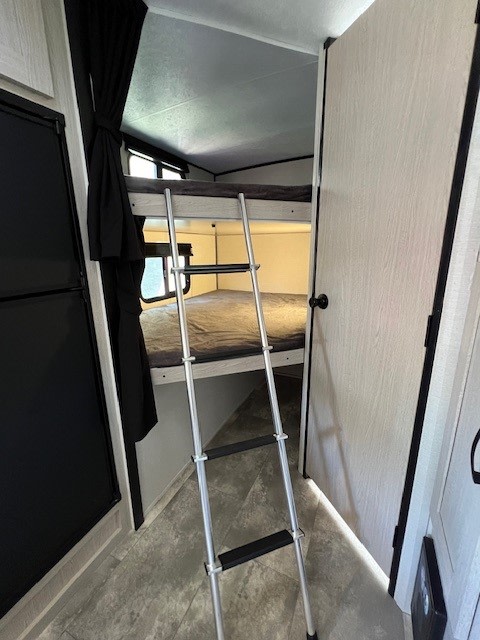 Explore this RV rental's interior featuring functional bunk beds with a ladder, ideal for extra sleeping space.. Coachmen Apex Nano 2022